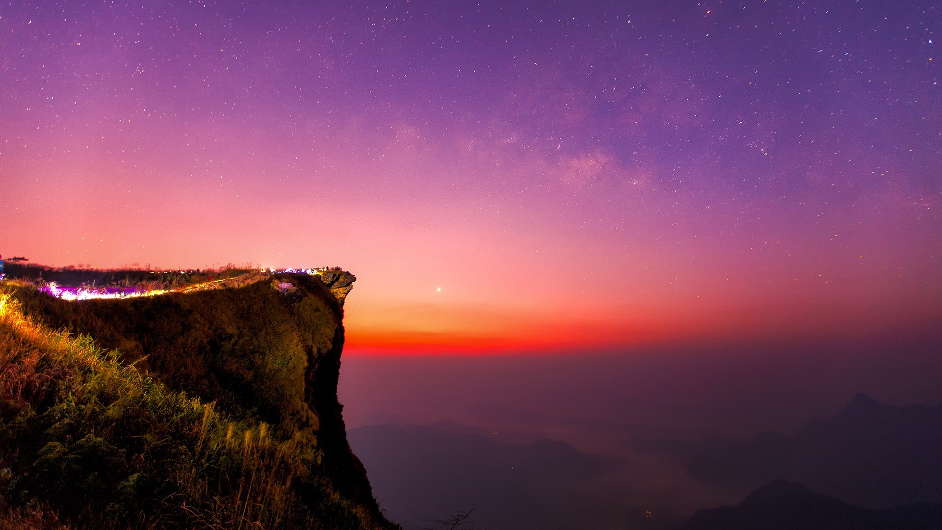 Cliff overlooking mountains at sunset with stars HD Wallpaper