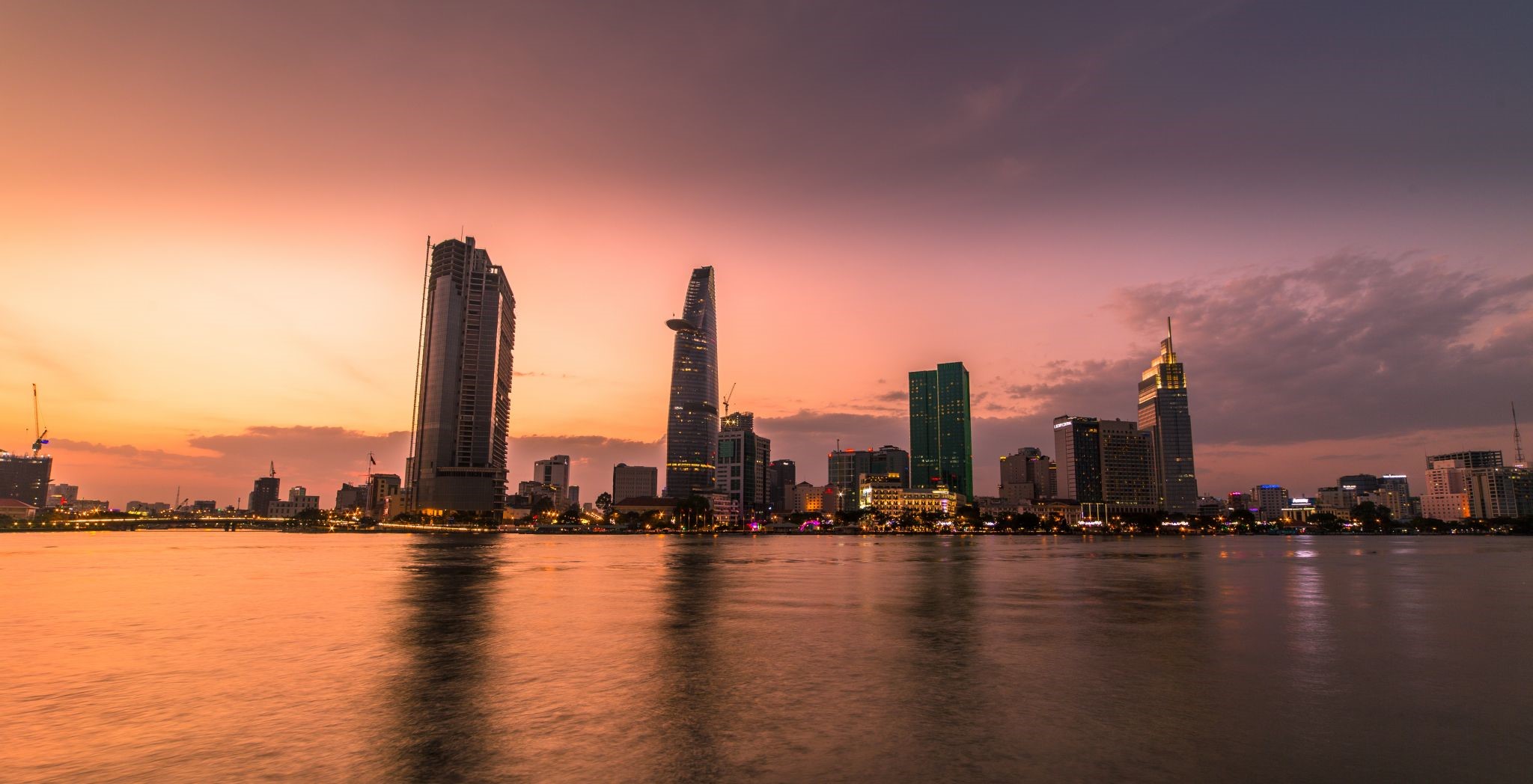 Cityscape skyline at sunset over a river in Vietnam HD Wallpaper
