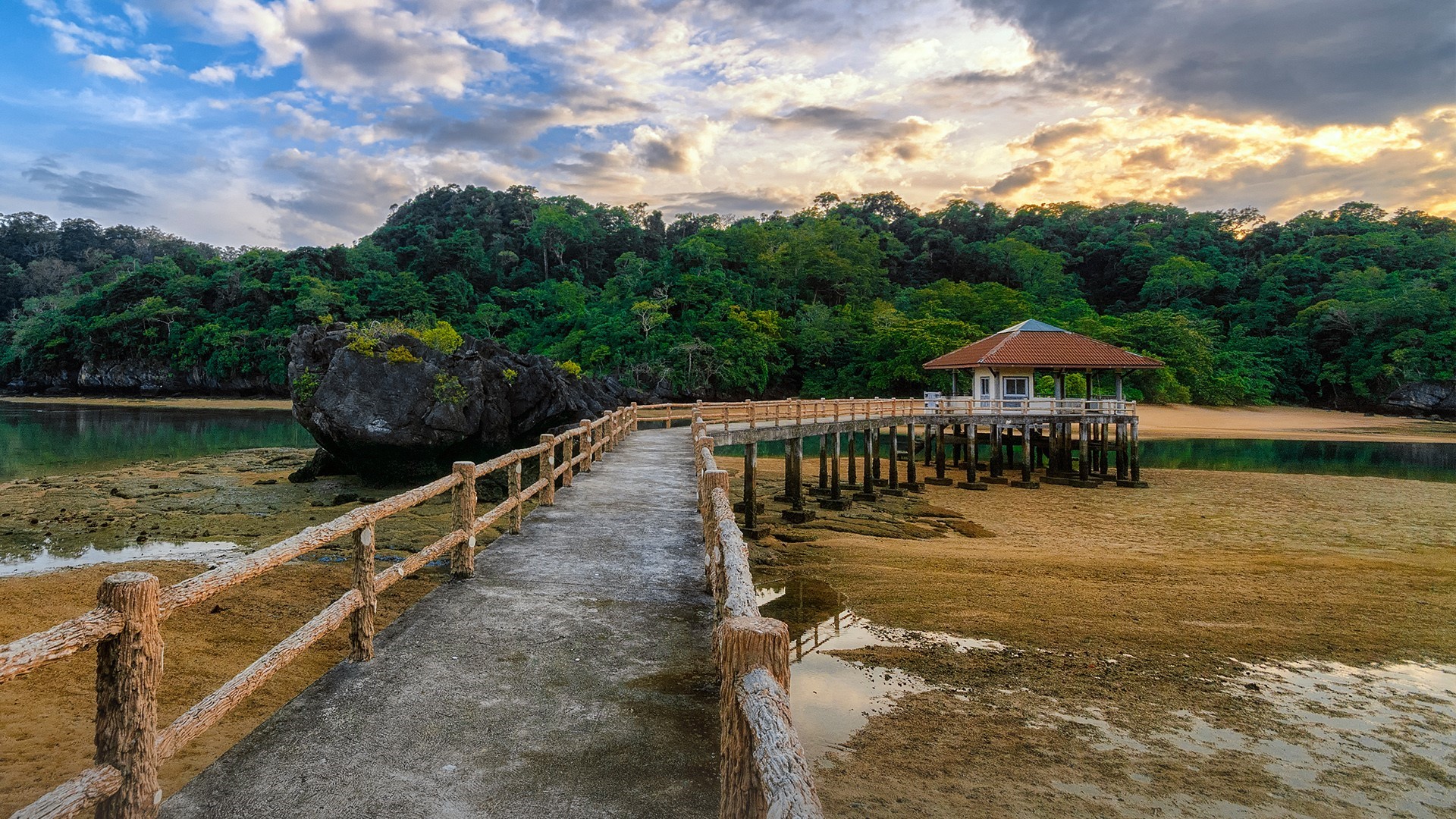 Wooden pier leading to a gazebo over a muddy shore with trees HD Wallpaper