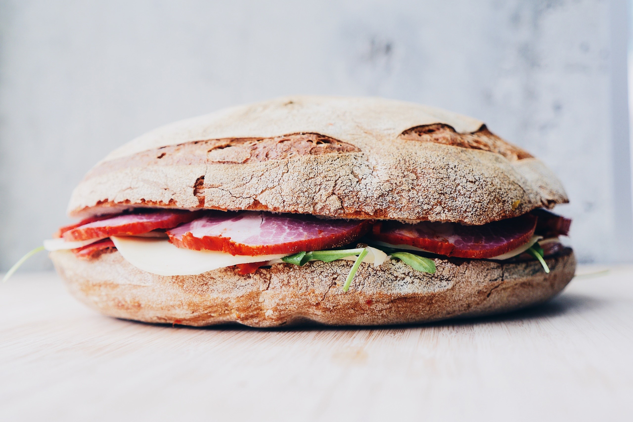 Sandwich with meat, cheese, and greens on bread HD Wallpaper