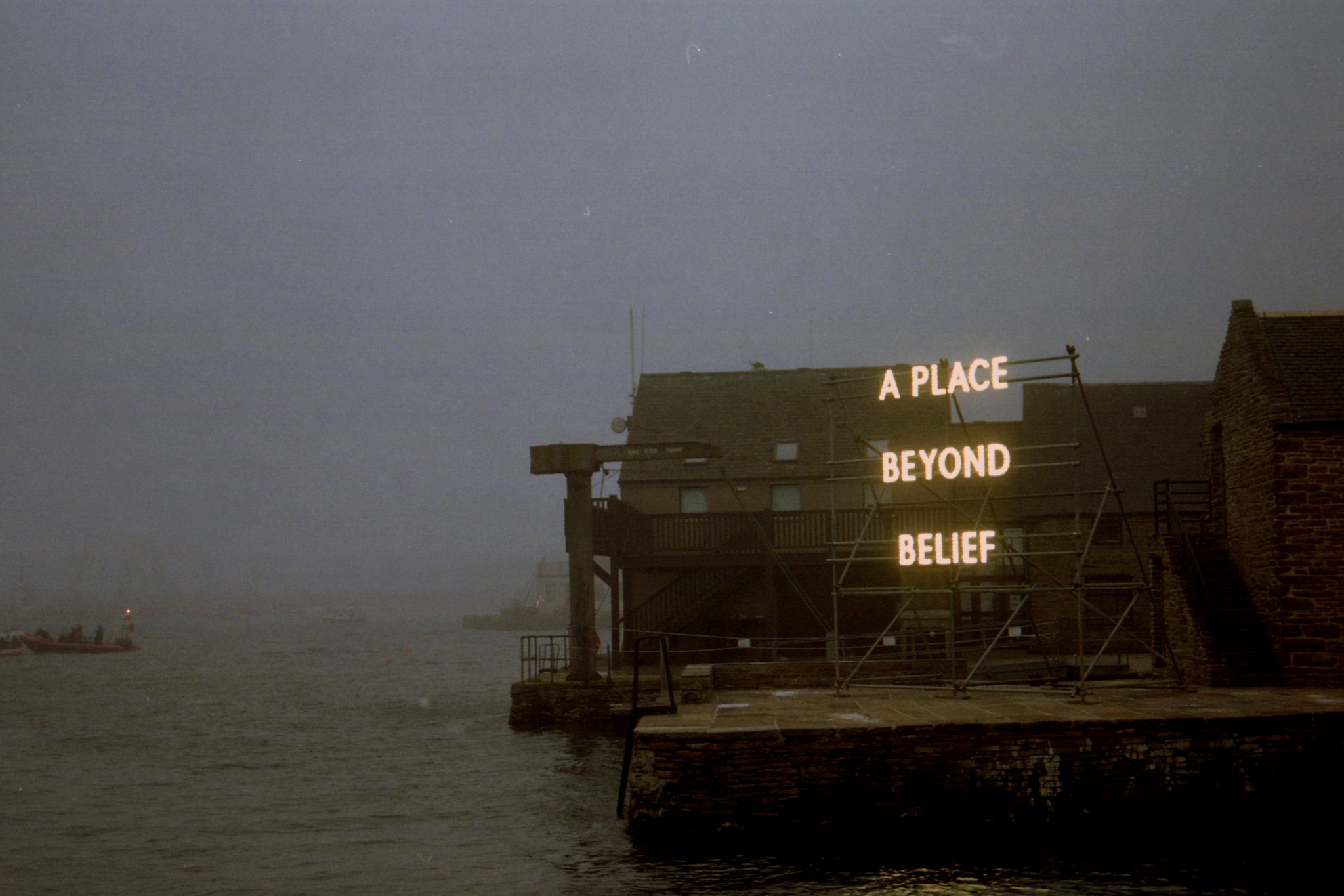 A Place Beyond Belief neon sign over water HD Wallpaper