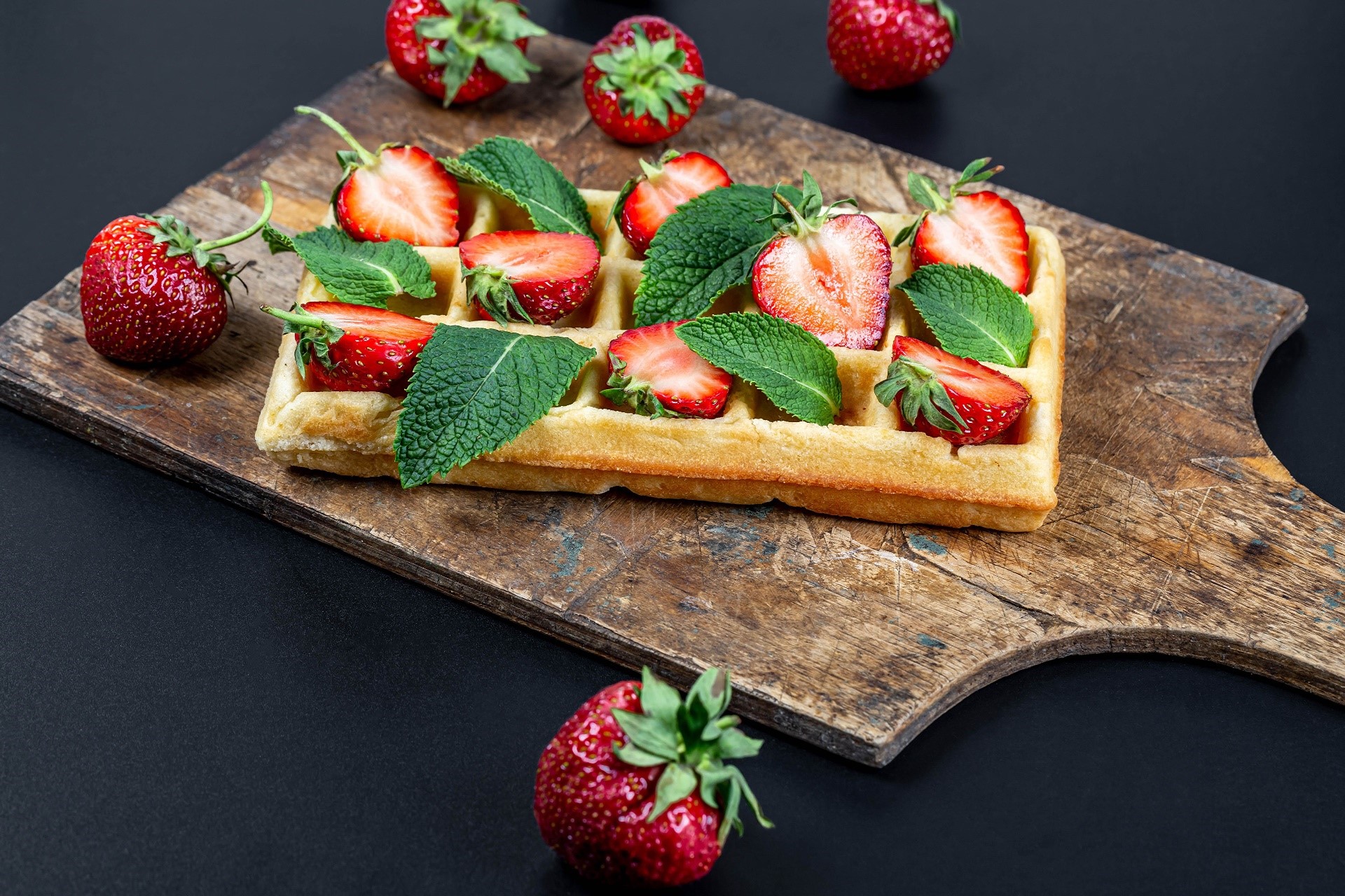 Waffle with strawberries and mint leaves on a wooden board HD Wallpaper