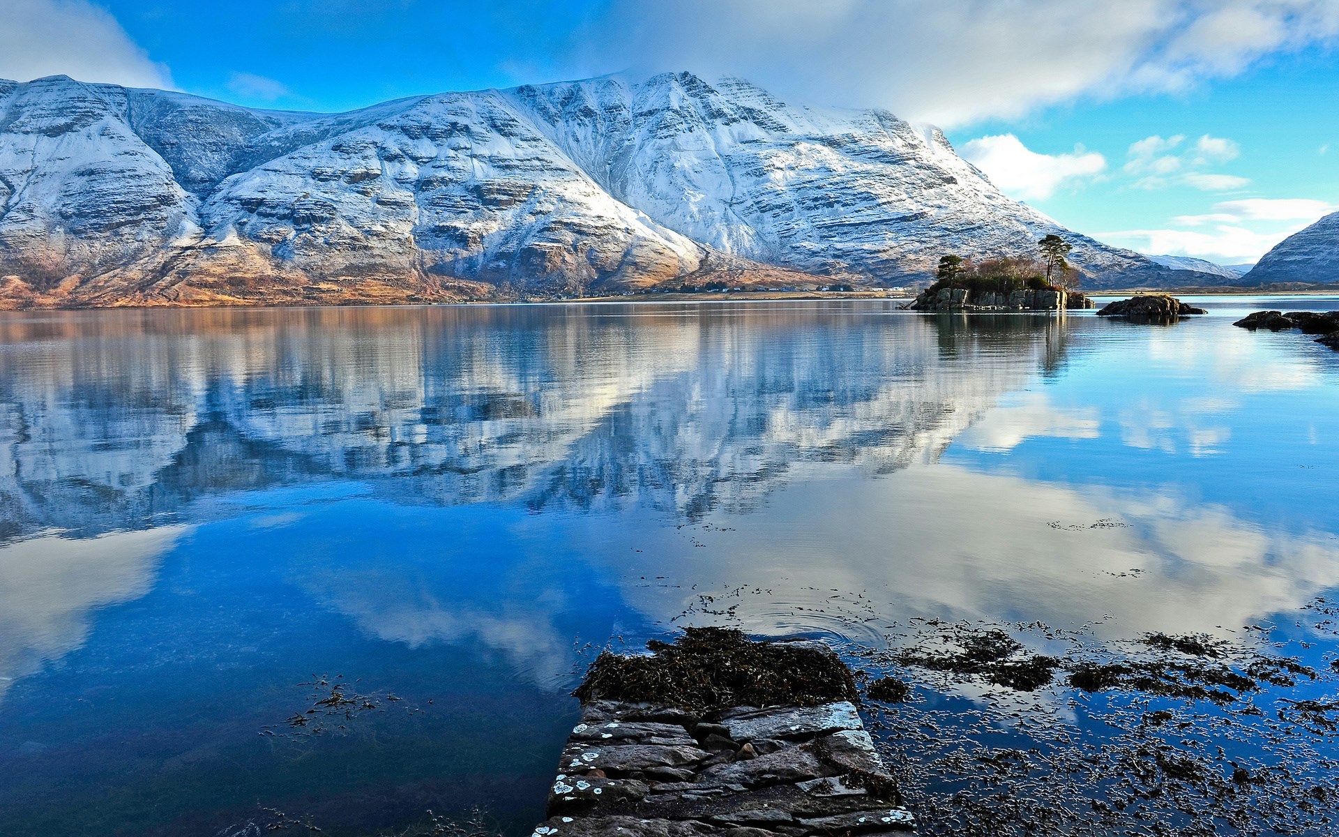 Snow-capped mountains reflected in a calm lake HD Wallpaper