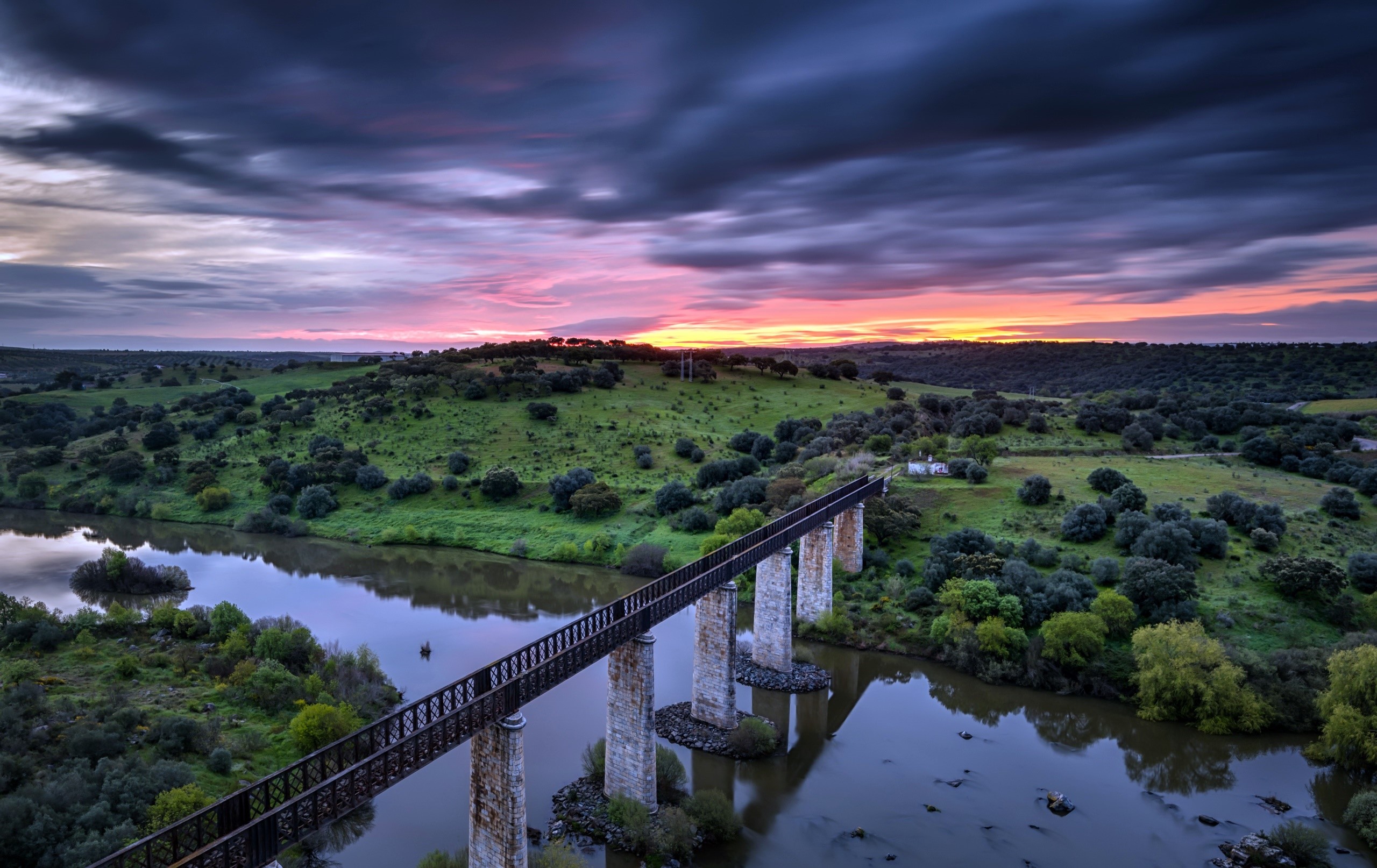 Bridge over river at sunset with dramatic sky HD Wallpaper