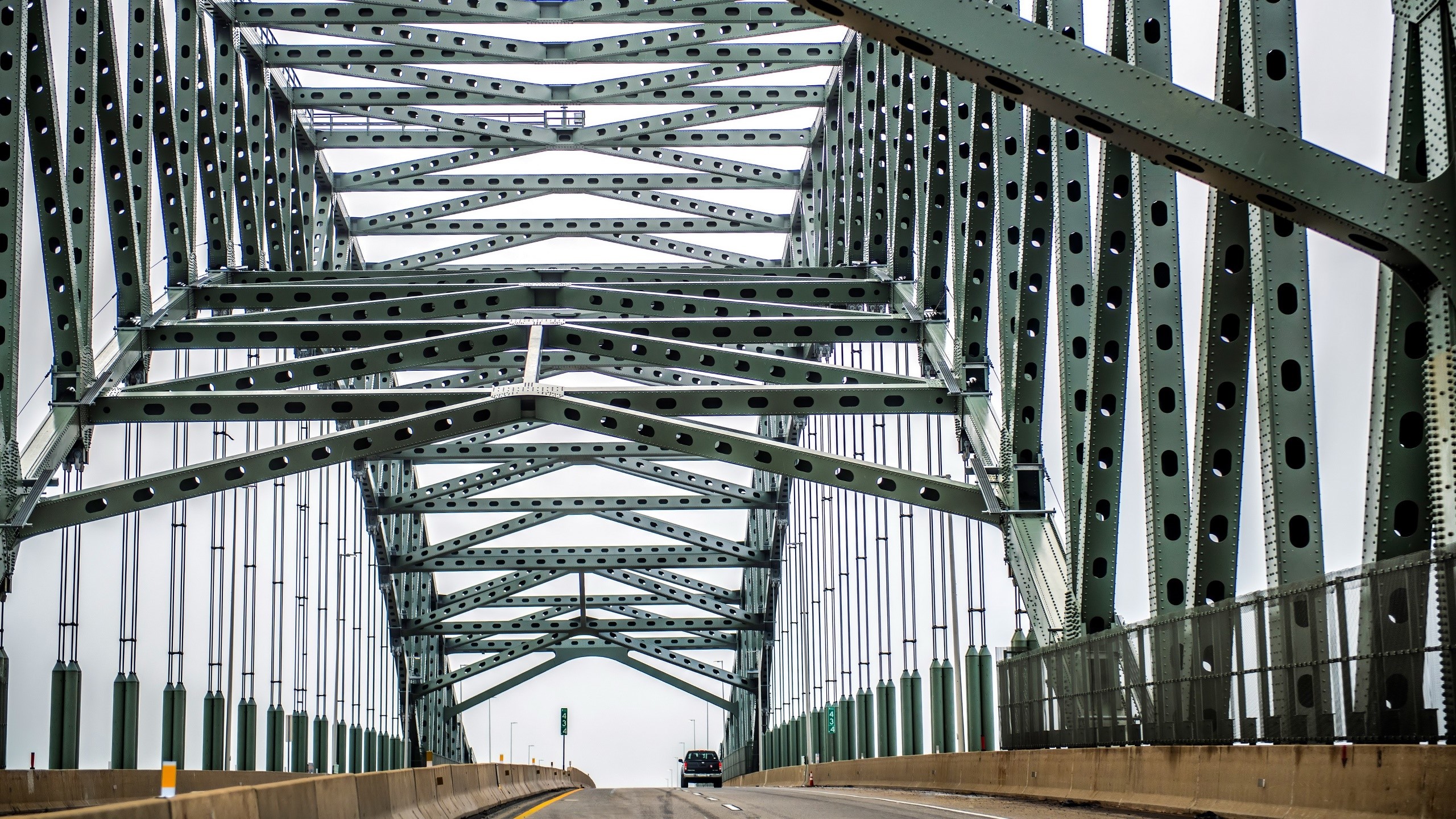 Green metal truss bridge over a road HD Wallpaper