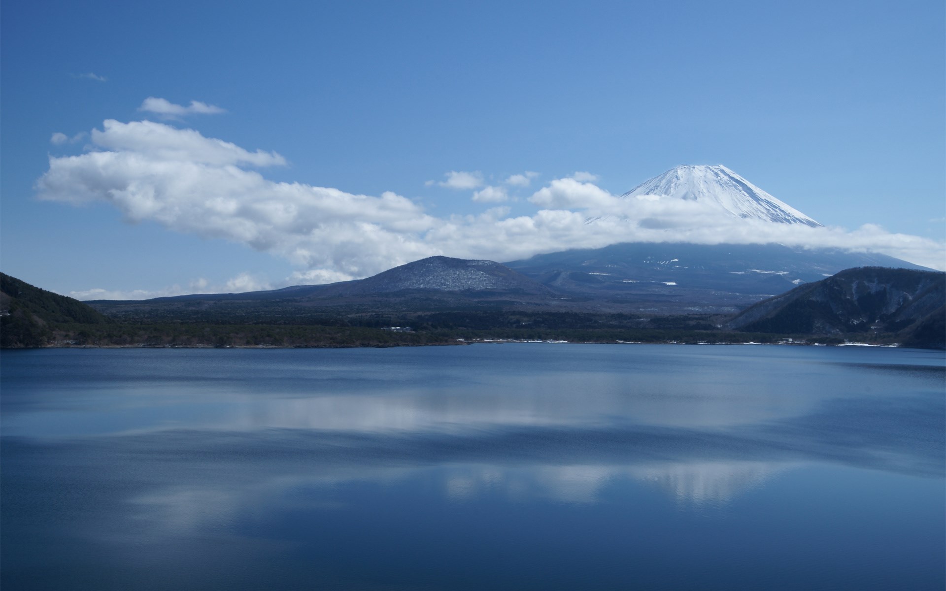 Mount Fuji reflected in a lake under a cloudy sky HD Wallpaper