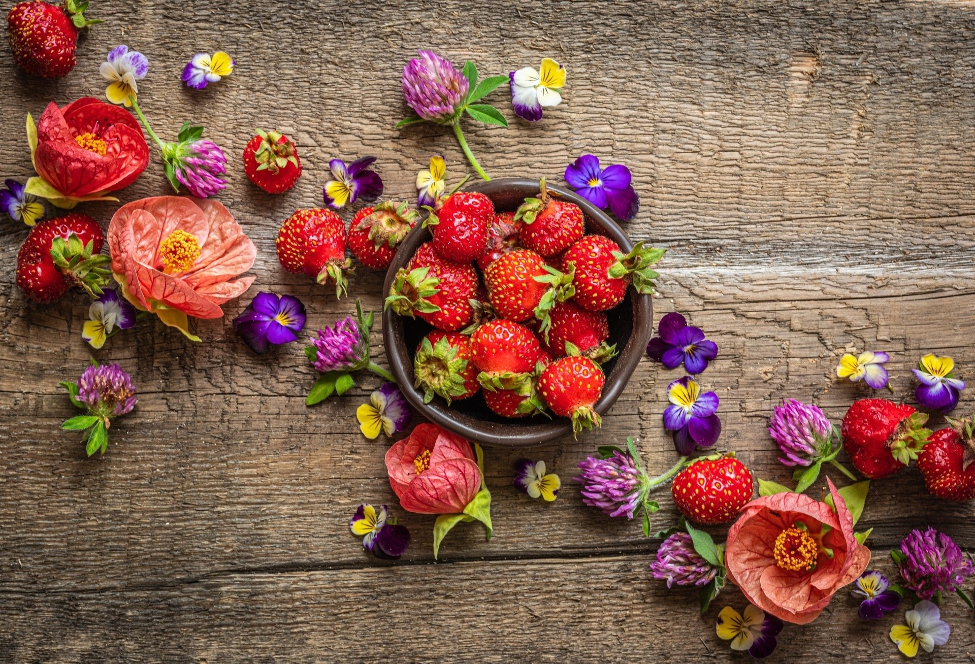 Strawberries and colorful flowers on a wooden table HD Wallpaper