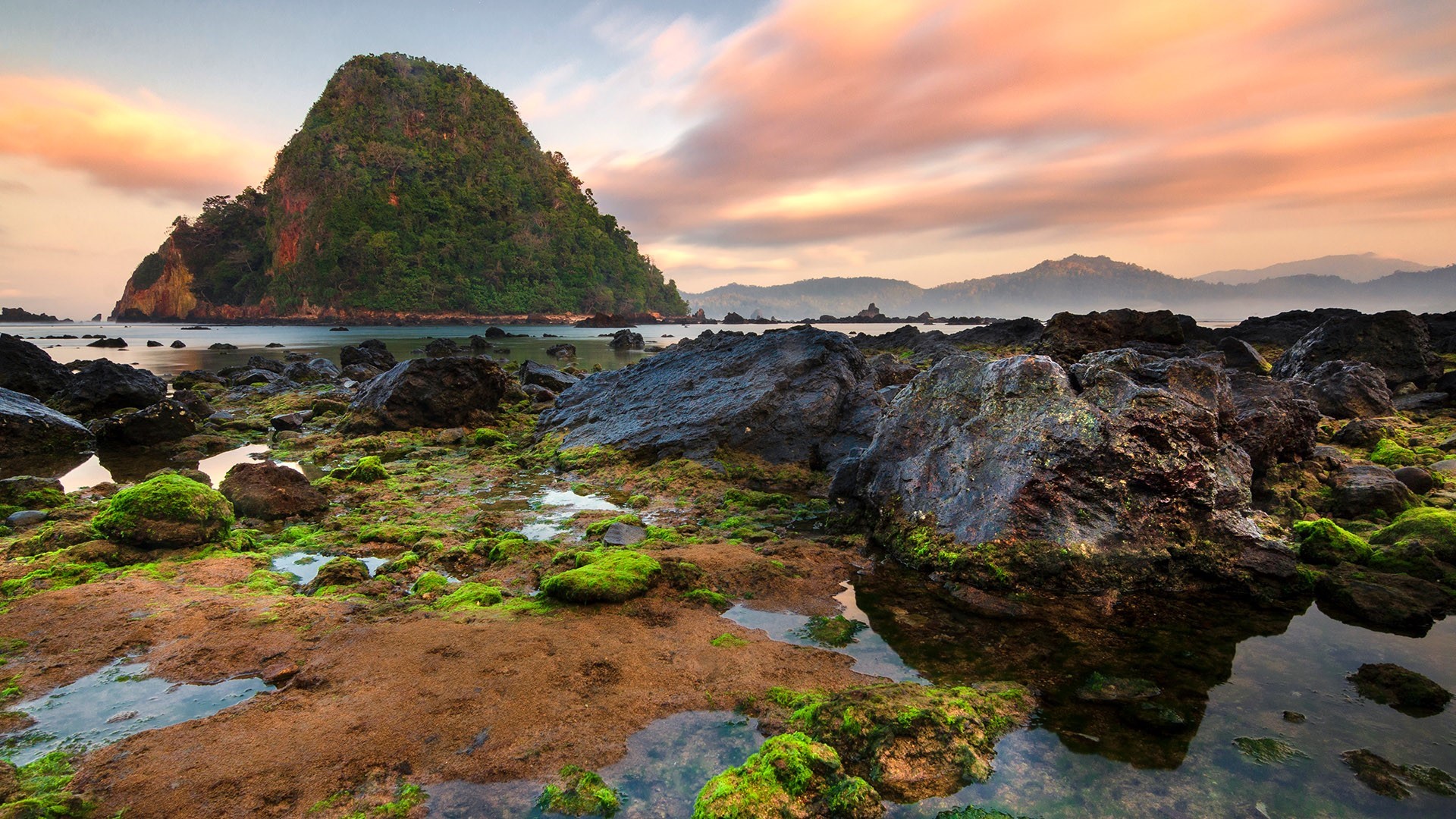 Rocky coastline with moss and a large island at sunrise HD Wallpaper