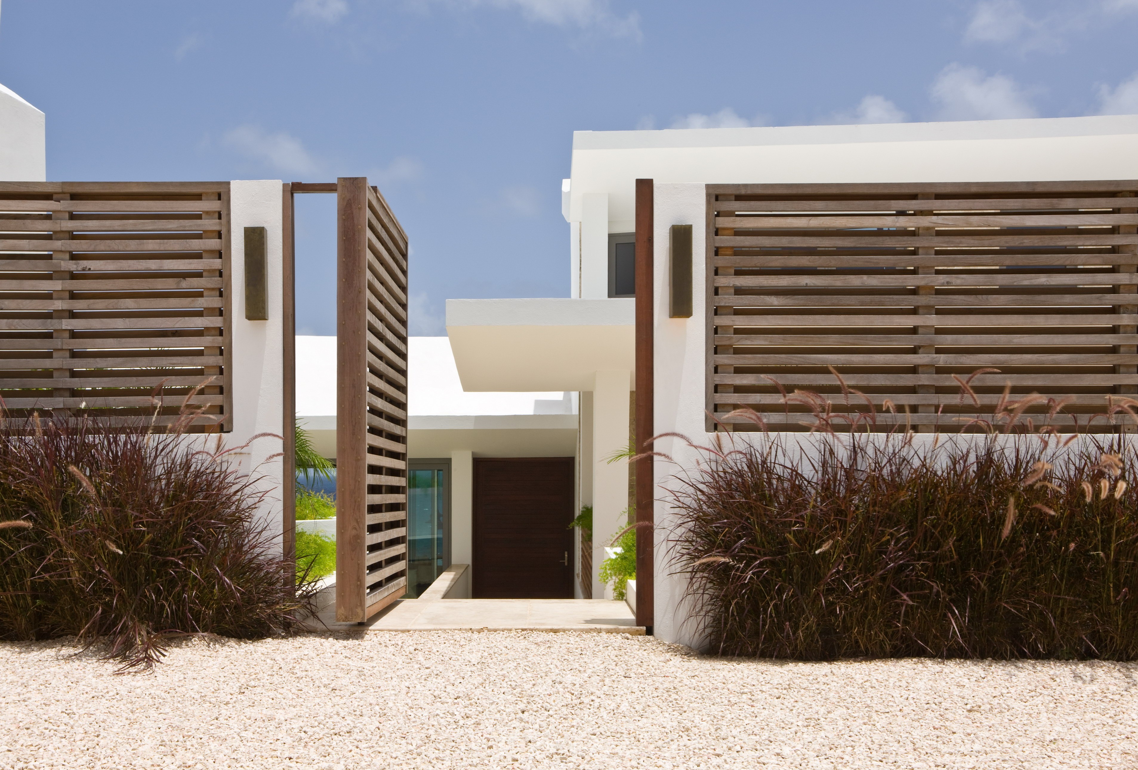 Modern house with wooden fence and gravel yard HD Wallpaper
