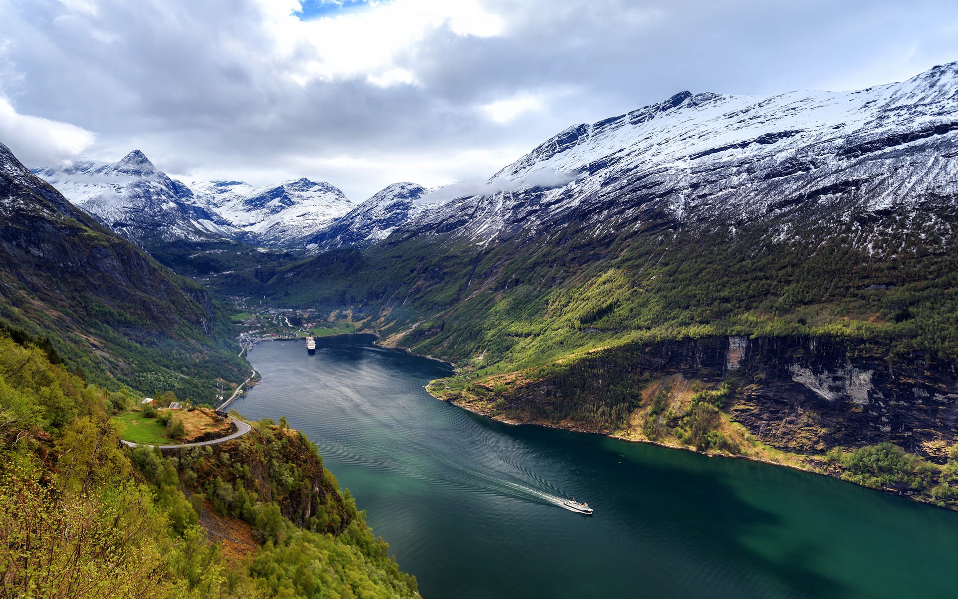 Cruise ship sailing through a Norwegian fjord with snow-capped mountains HD Wallpaper