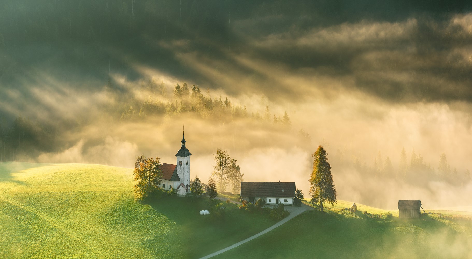 Church and houses on a misty hill in Slovenia HD Wallpaper