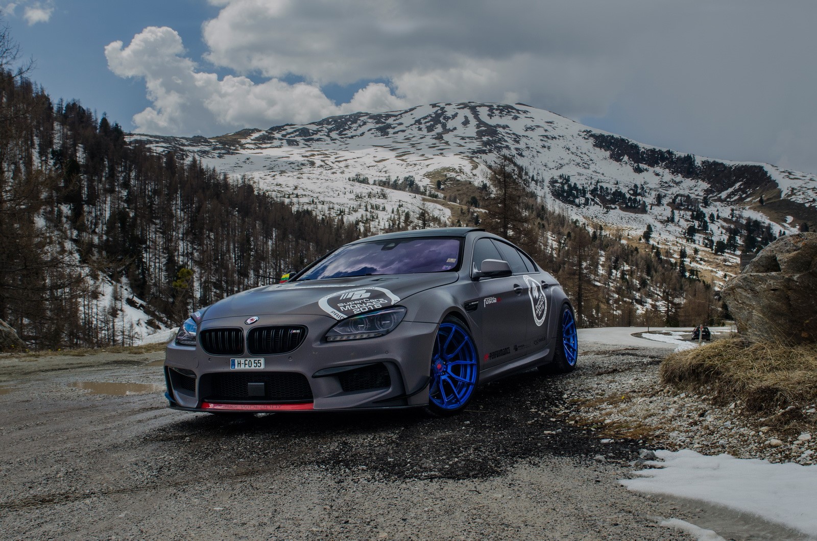 Matte gray BMW M6 with blue wheels in mountains HD Wallpaper