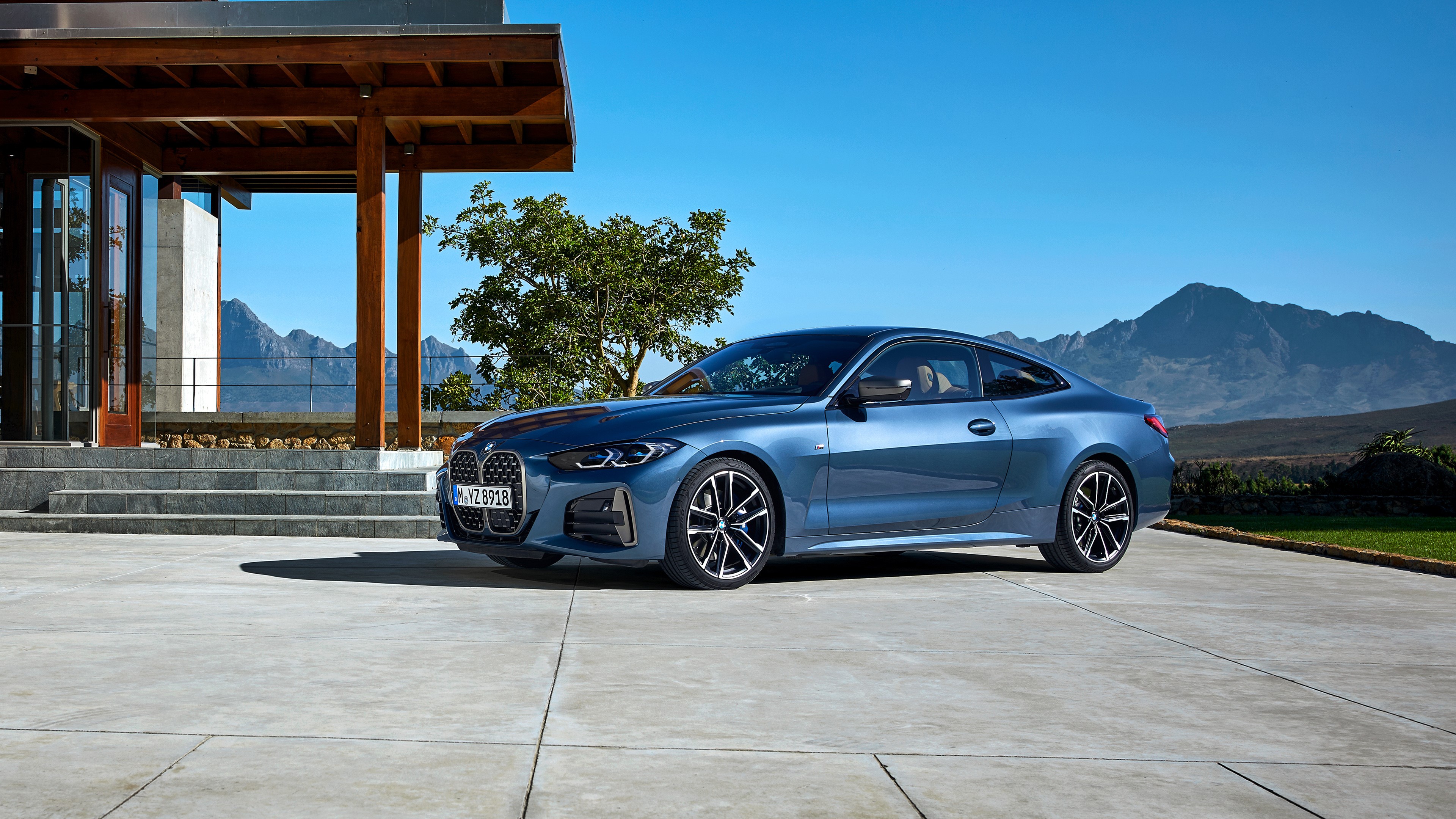 Blue BMW M440i parked in front of a modern house HD Wallpaper