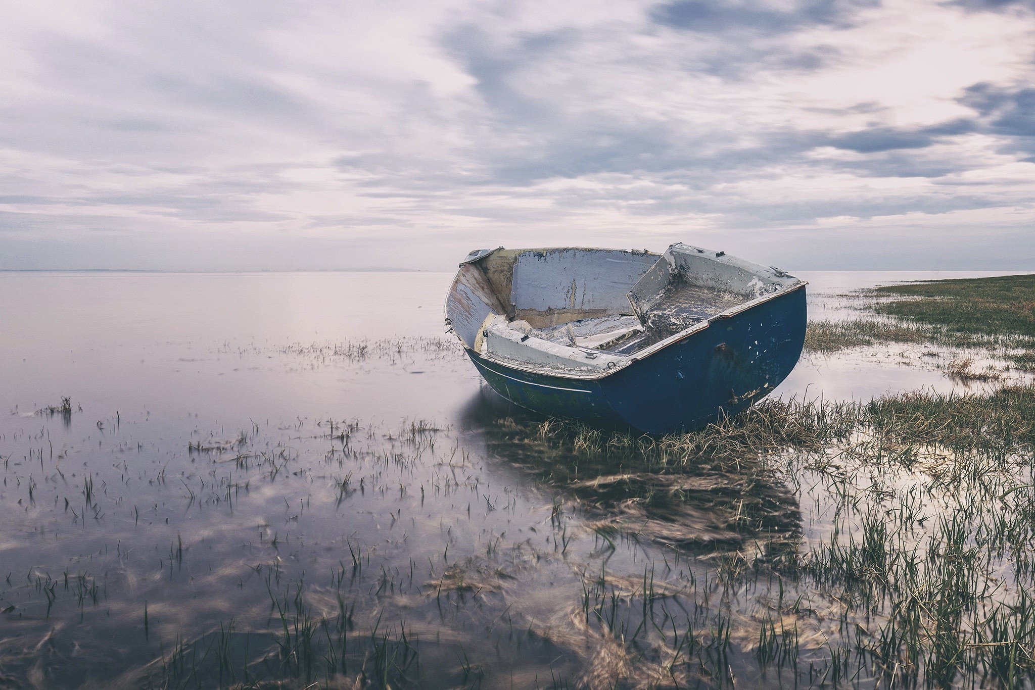 Abandoned boat on a calm shore HD Wallpaper