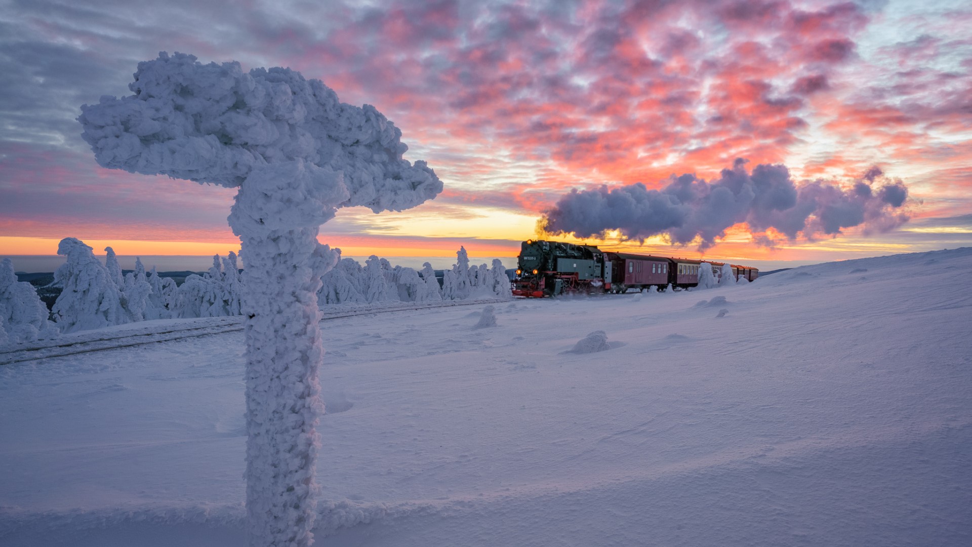 Steam train in a snowy landscape at sunset HD Wallpaper