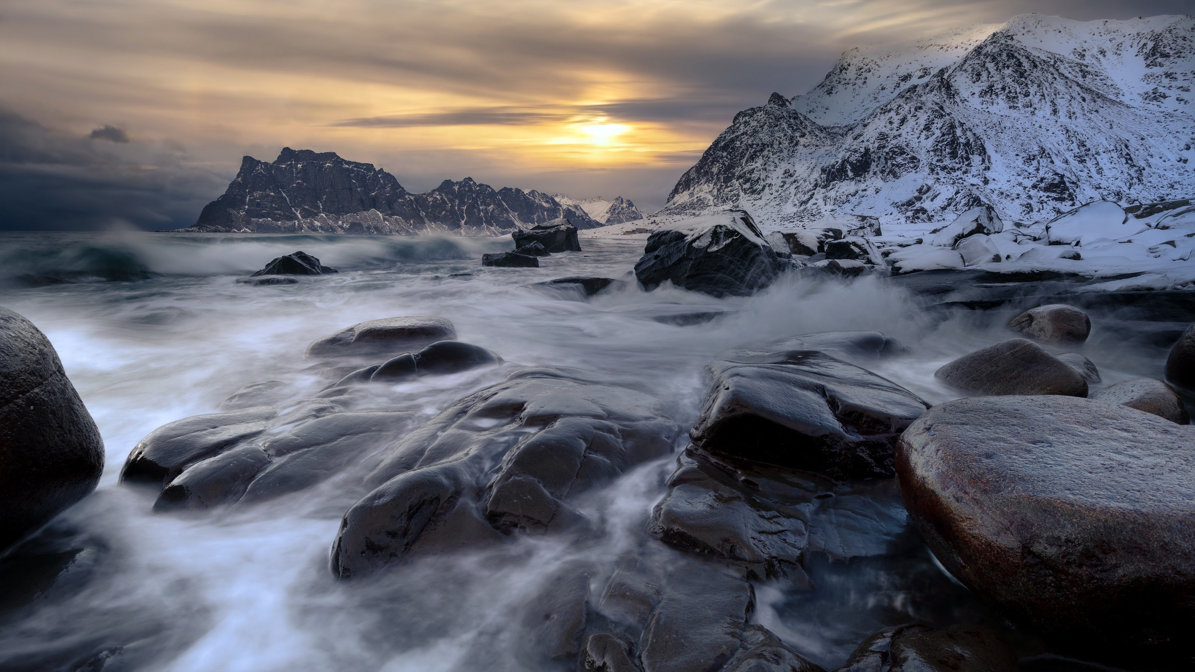 4K sunset over snowy mountains and rocky coast with waves HD Wallpaper