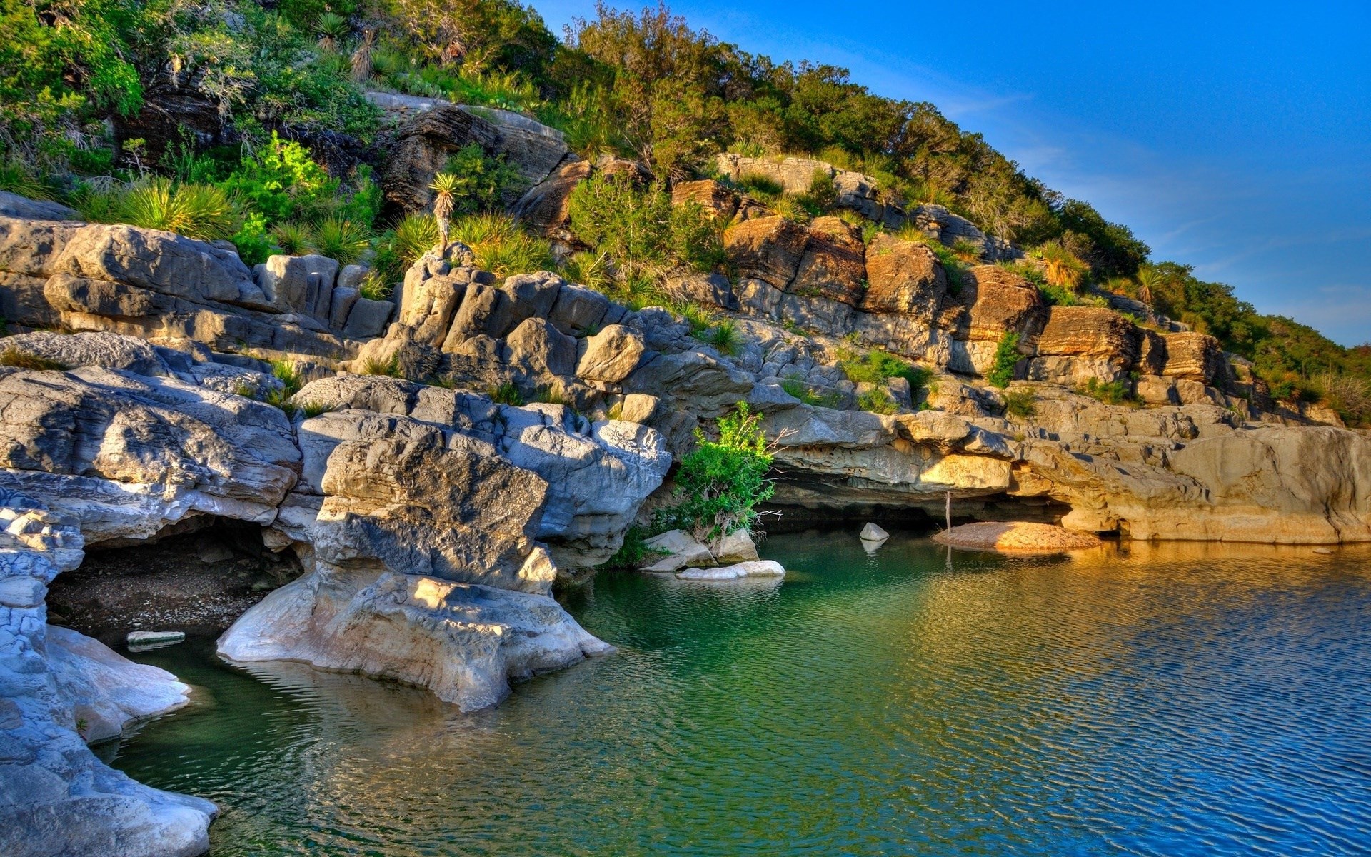 Rocky cliff face with a river and trees HD Wallpaper
