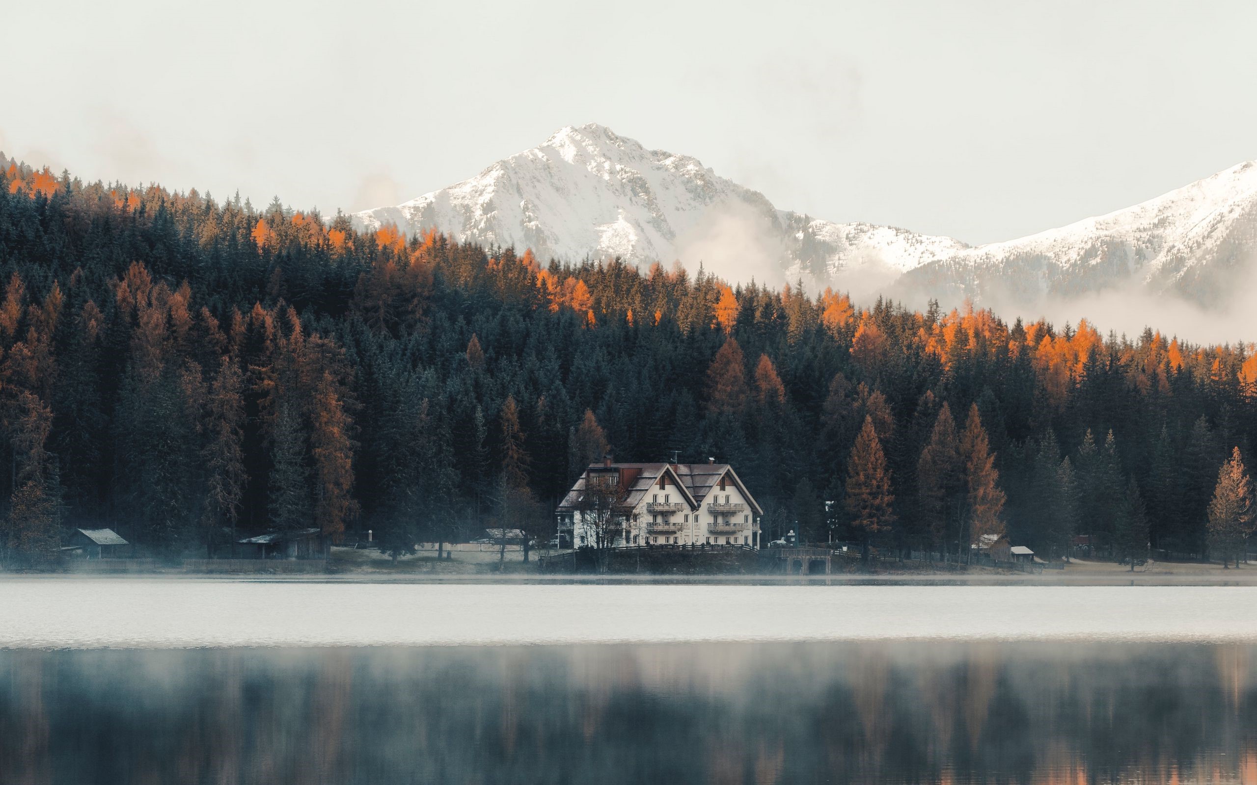 House by a lake with autumn forest and snowy mountains HD Wallpaper
