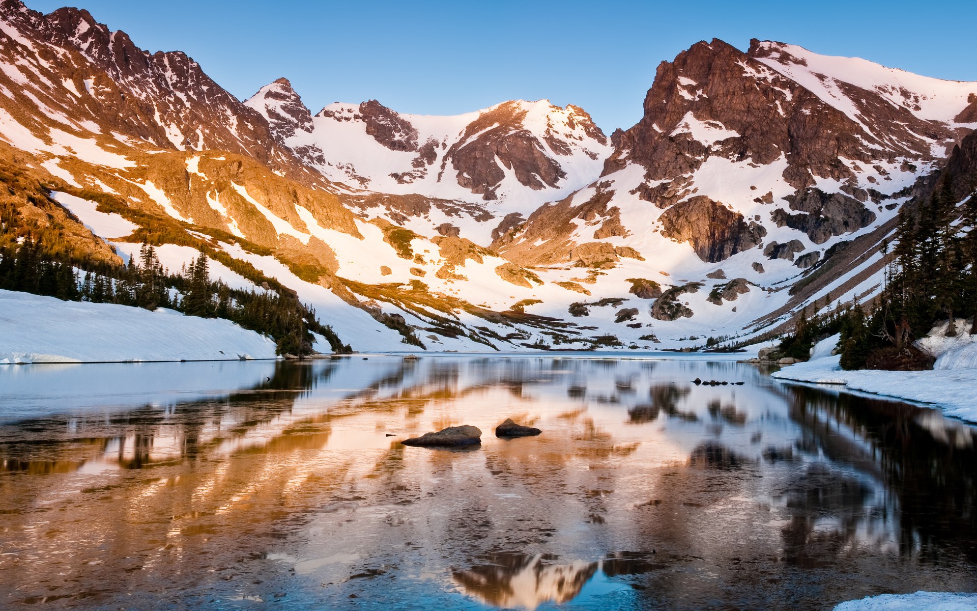 Snow-covered mountains reflected in a calm lake HD Wallpaper