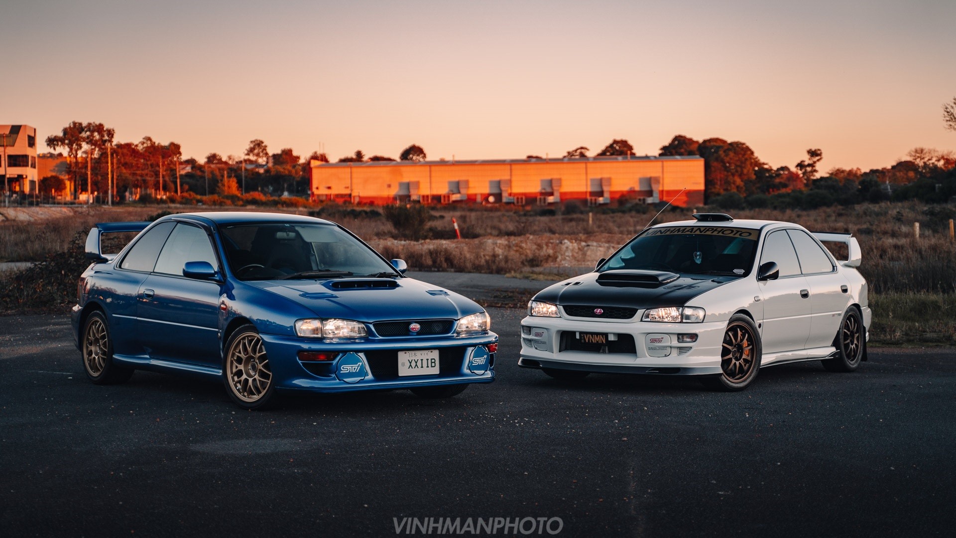 Two Subaru Impreza WRX STi cars, one blue, one white HD Wallpaper