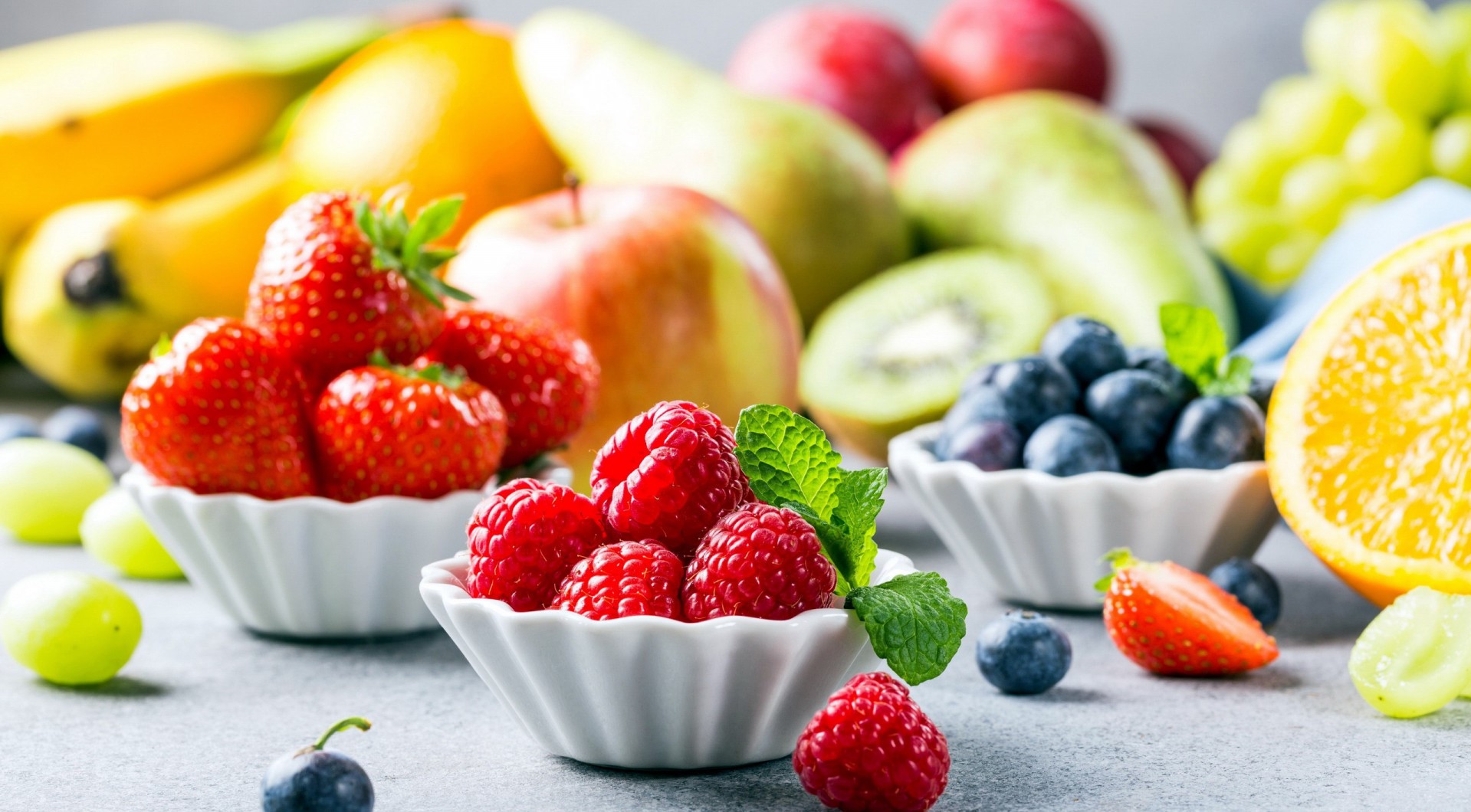 Assortment of fresh fruits including berries, bananas, and oranges HD Wallpaper