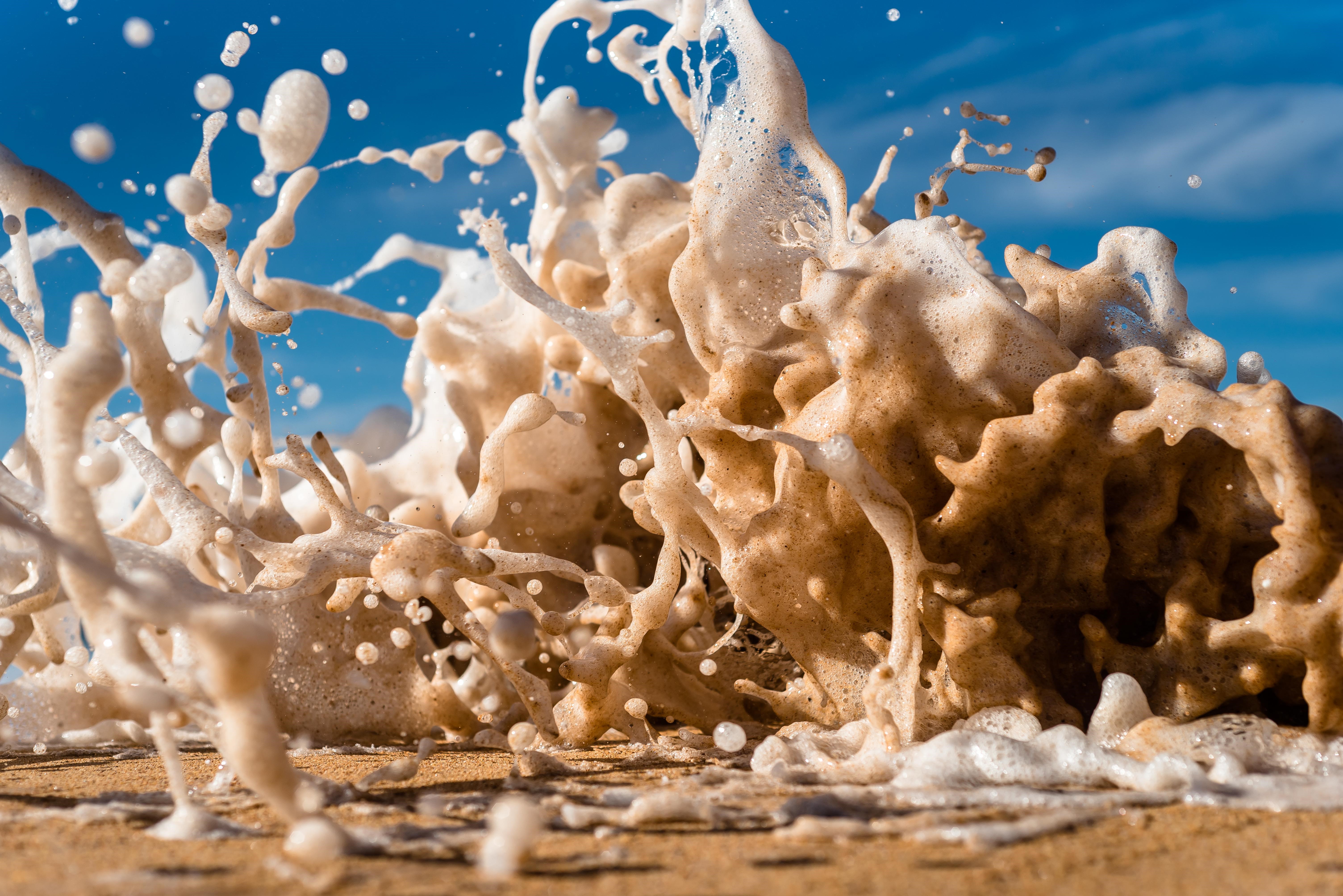 4K wave splashes on a sandy beach HD Wallpaper