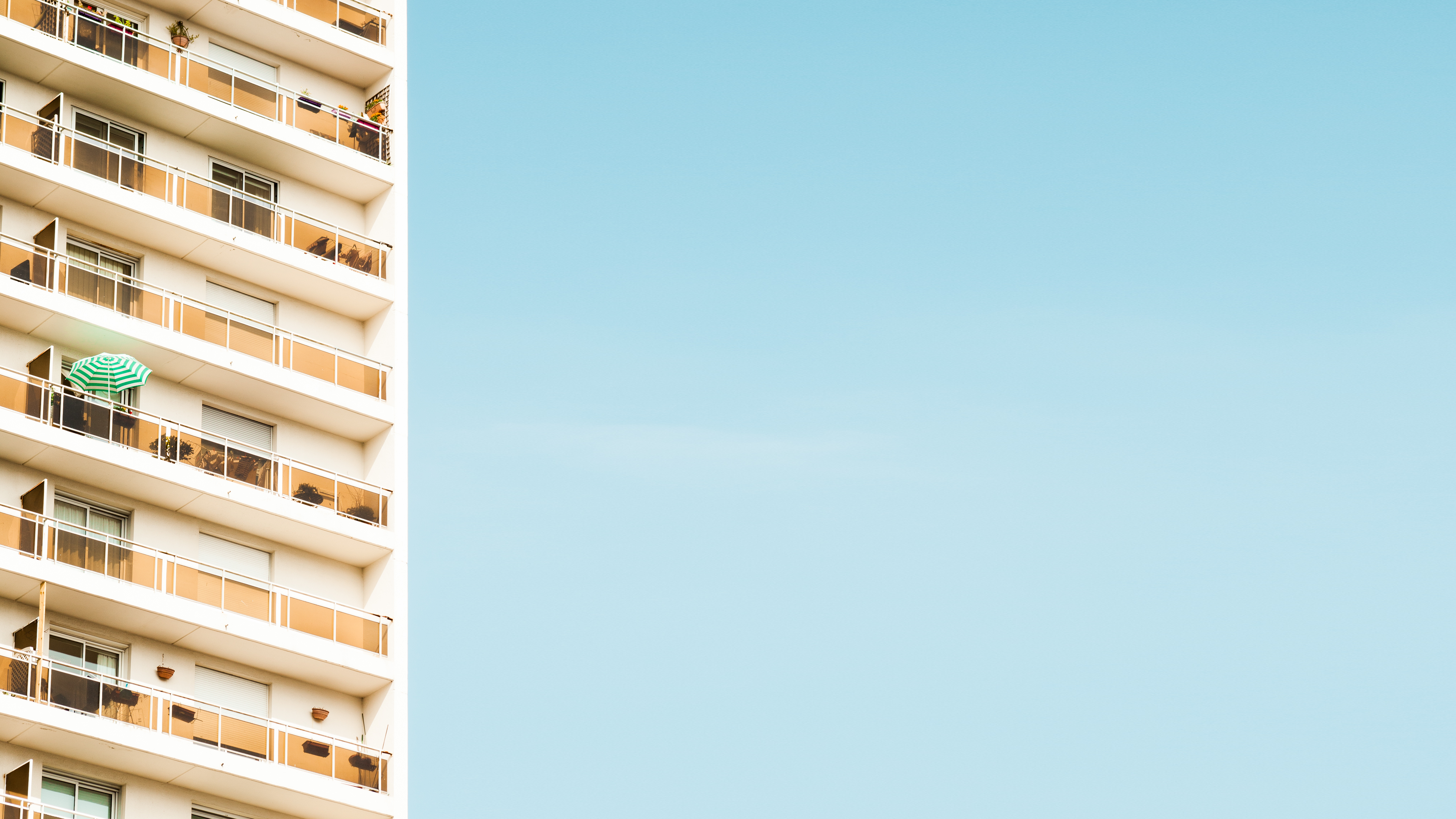Architecture with balconies and a green umbrella HD Wallpaper