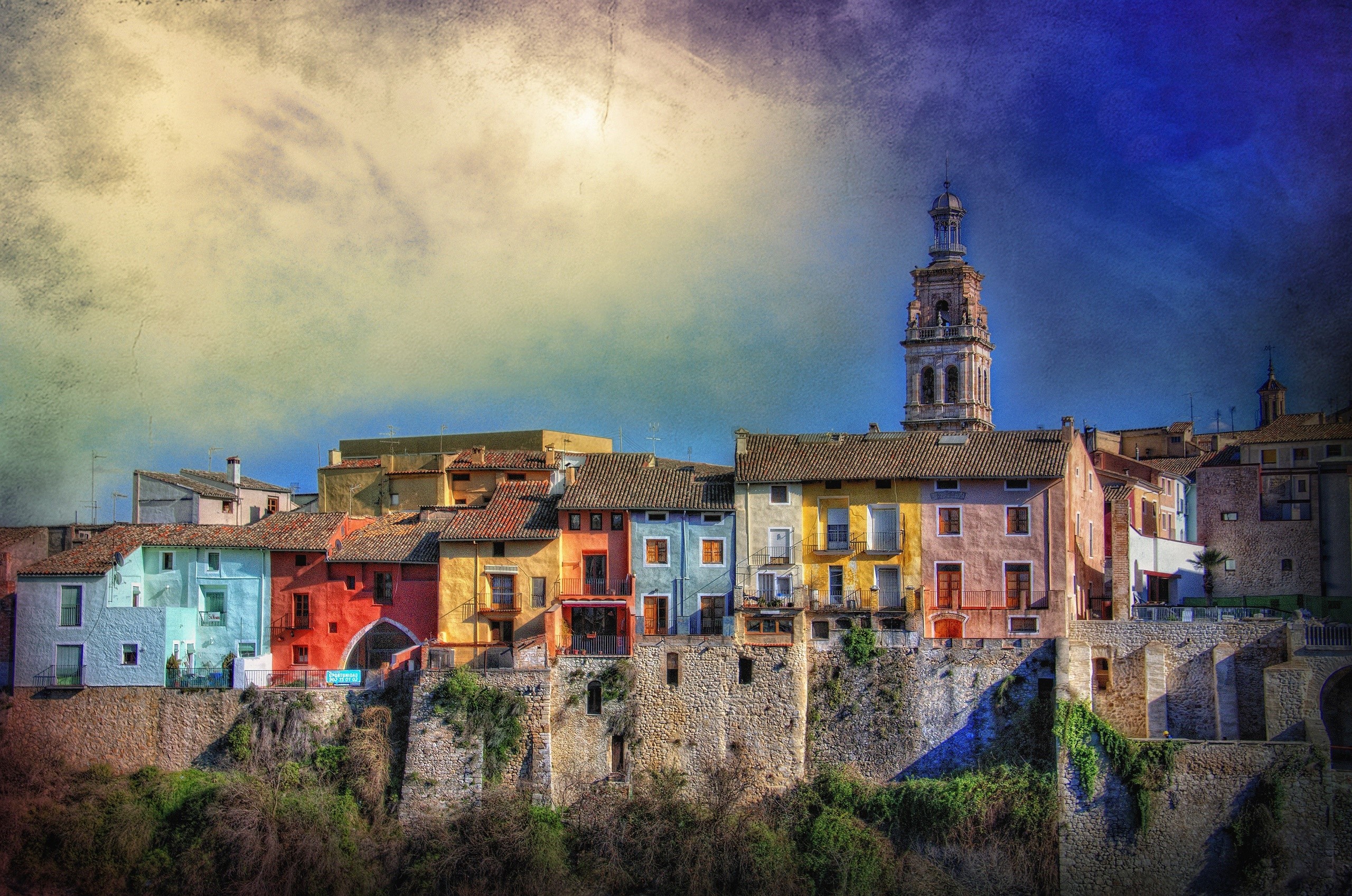 Colorful buildings on a cliffside with a church tower in Valencia, Spain HD Wallpaper