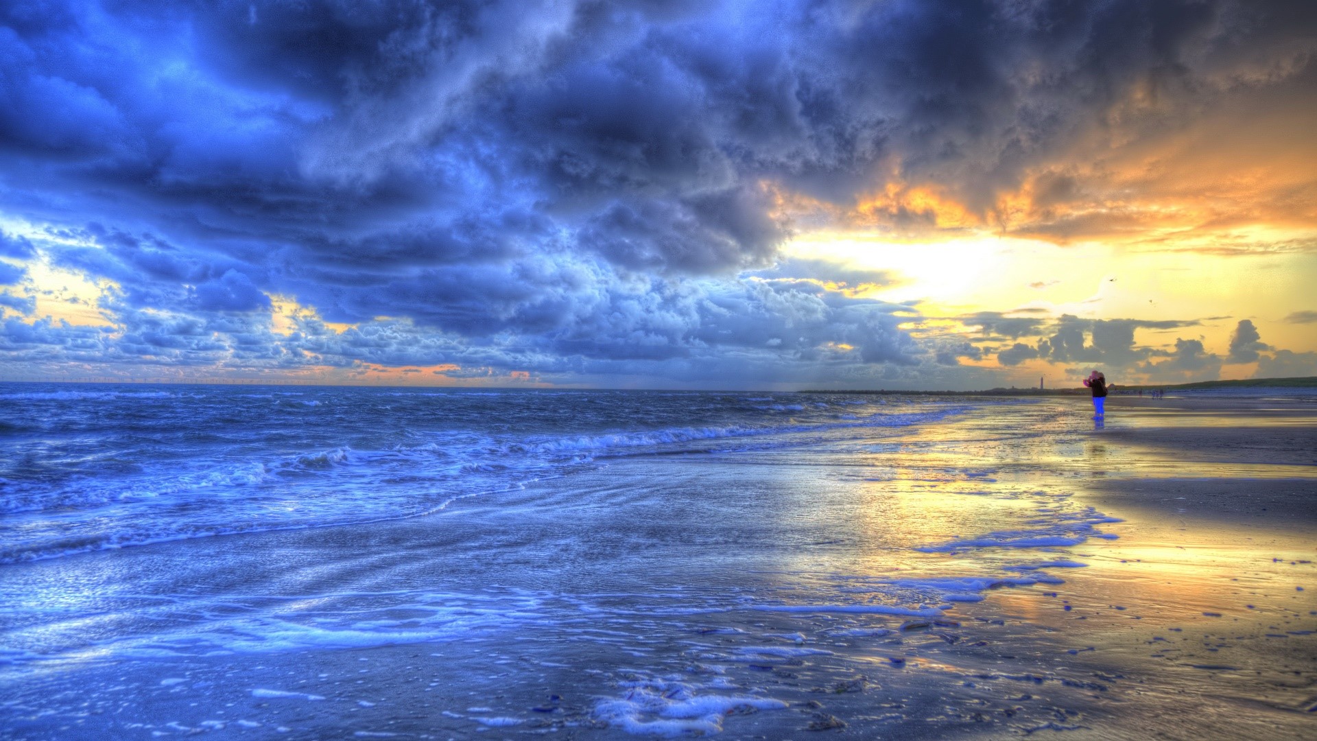 Person on a beach with dramatic clouds at sunset HD Wallpaper