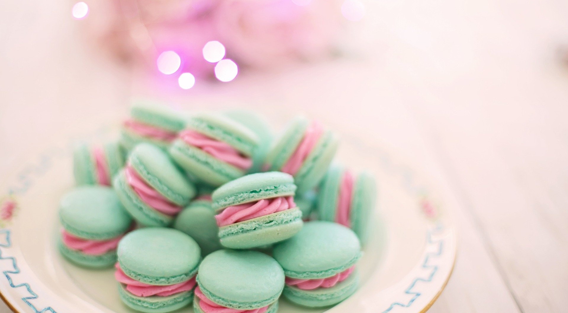 Mint green macarons with pink filling on a plate HD Wallpaper