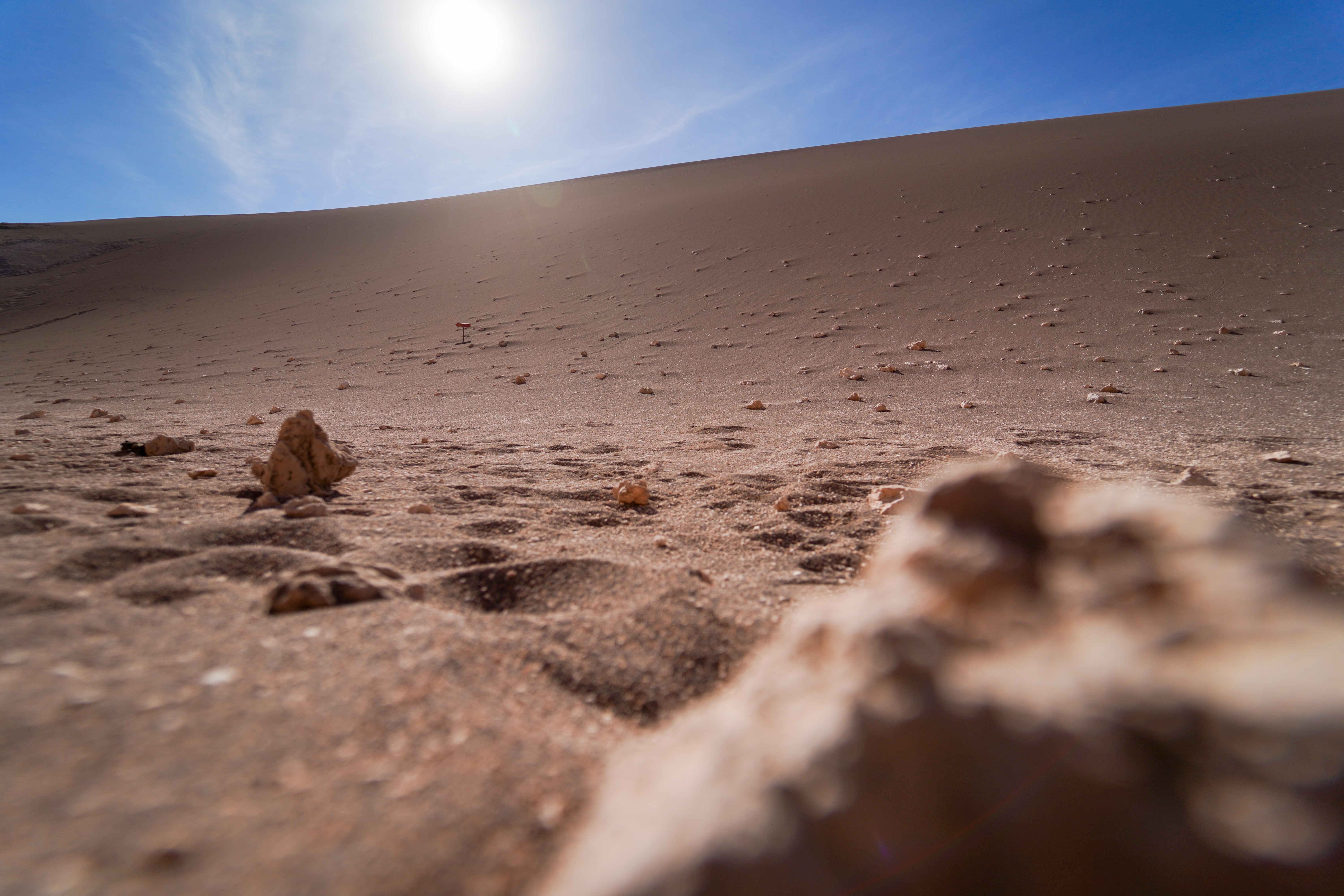 Desert sand dunes with stones and sun in Chile HD Wallpaper
