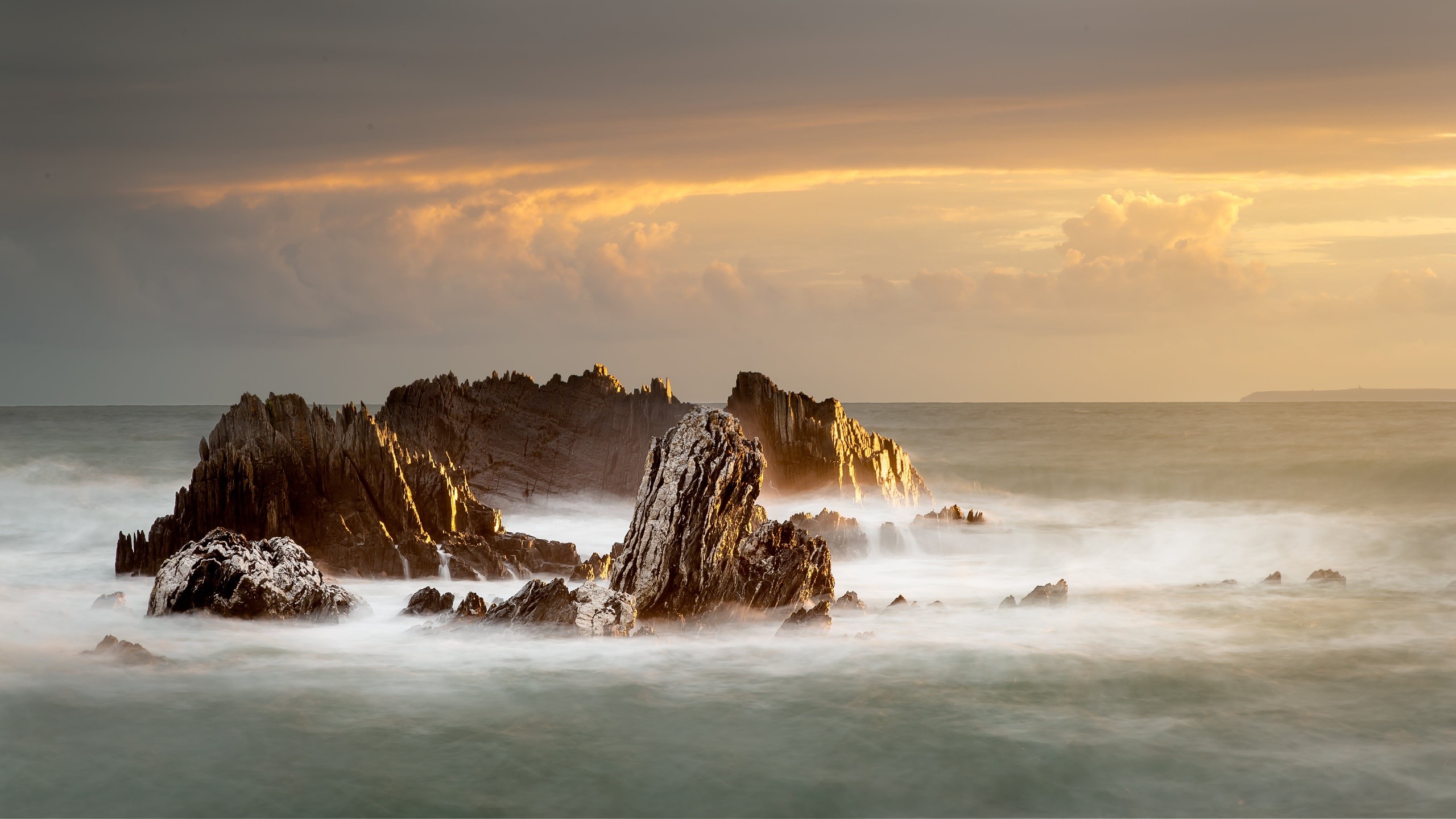 Jagged rocks in the sea at sunset HD Wallpaper