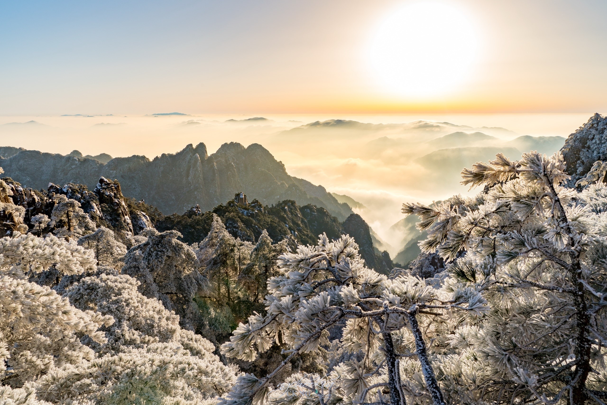 Winter mountain landscape with frost-covered trees and sunrise over clouds HD Wallpaper
