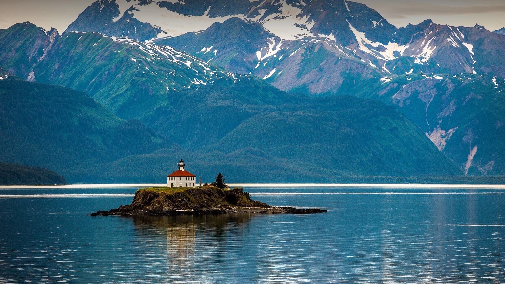 Lighthouse on an island in Alaska with mountains HD Wallpaper