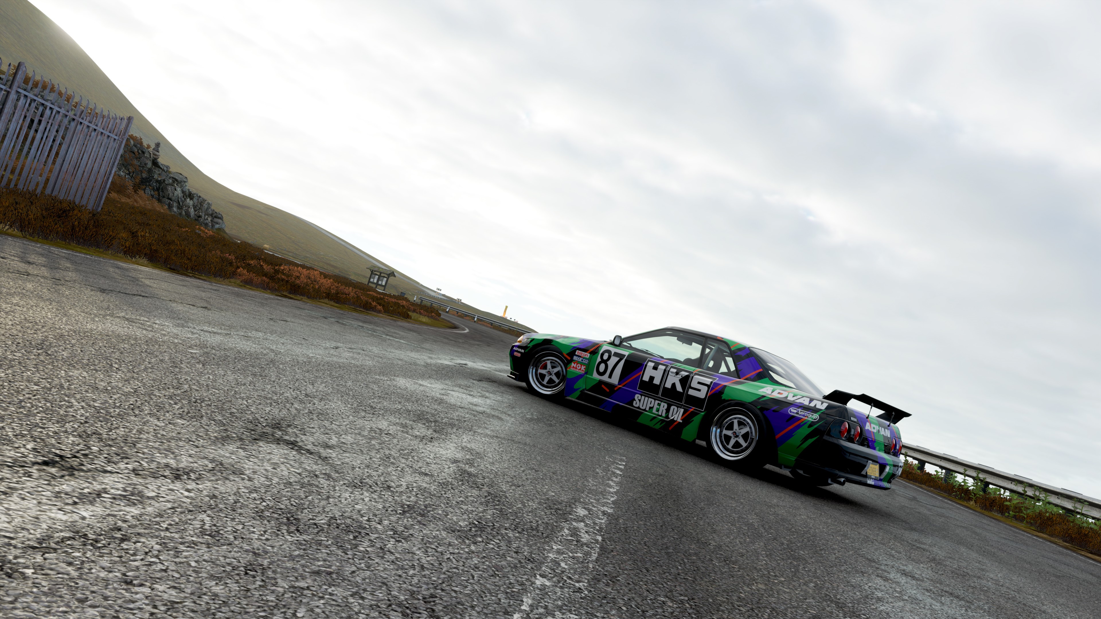 Nissan Skyline R32 with HKS livery on a race track HD Wallpaper