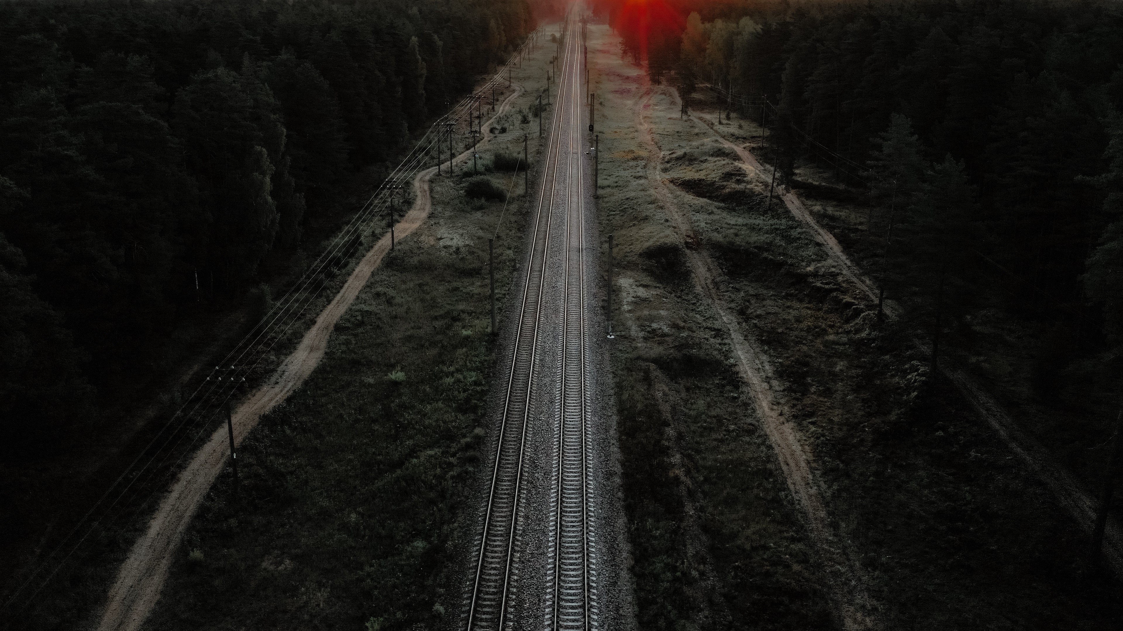 4K dark railway through trees HD Wallpaper