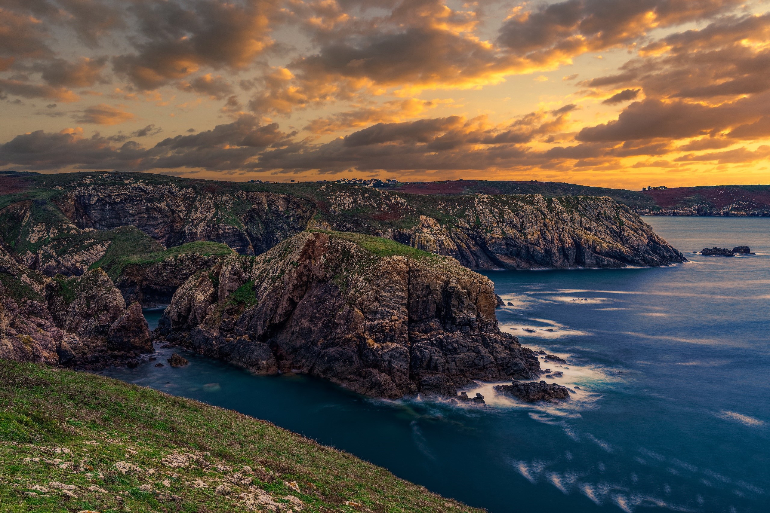 Rocky coast of France at sunset with dramatic clouds HD Wallpaper