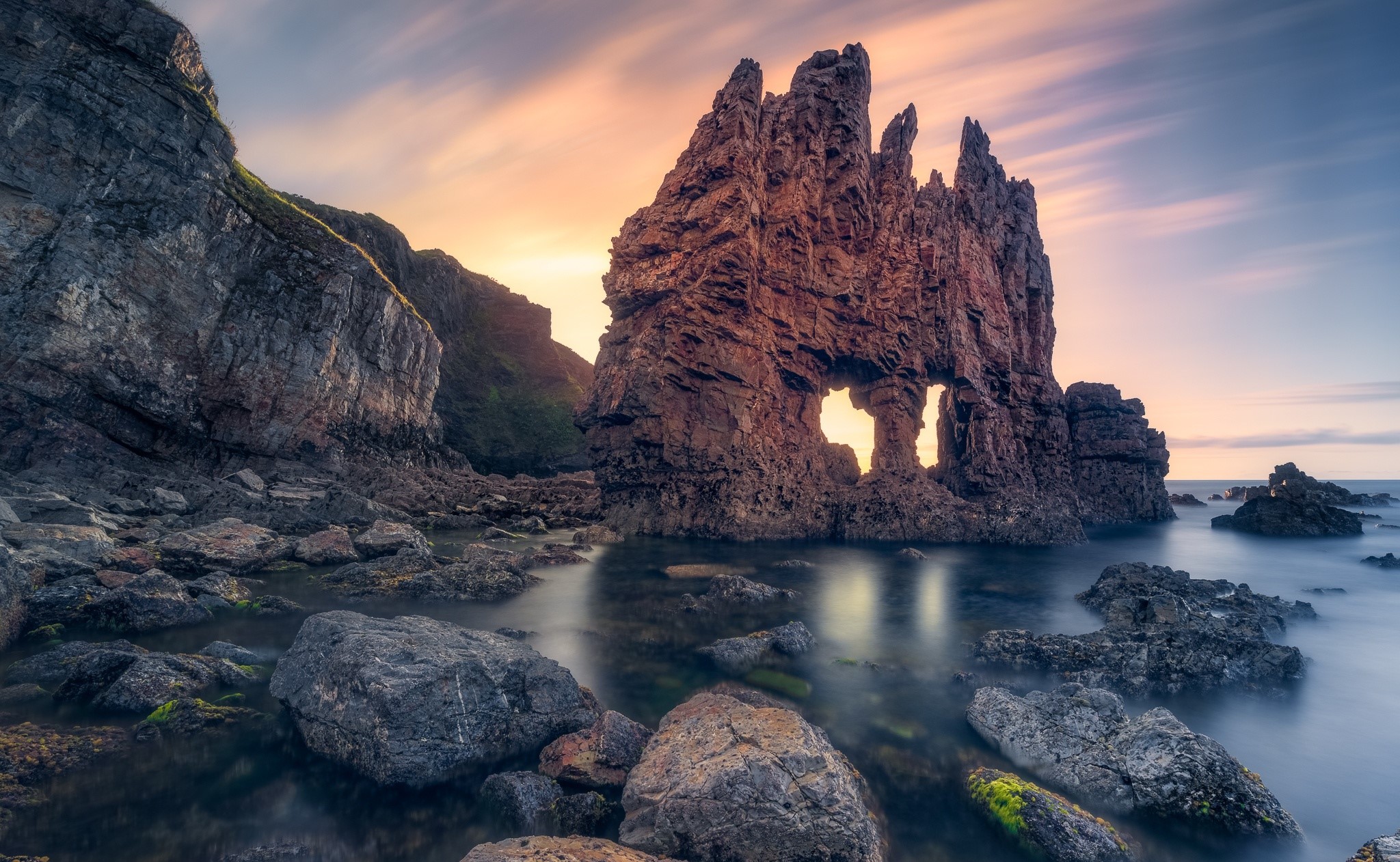 Rock formations in the sea at sunset HD Wallpaper