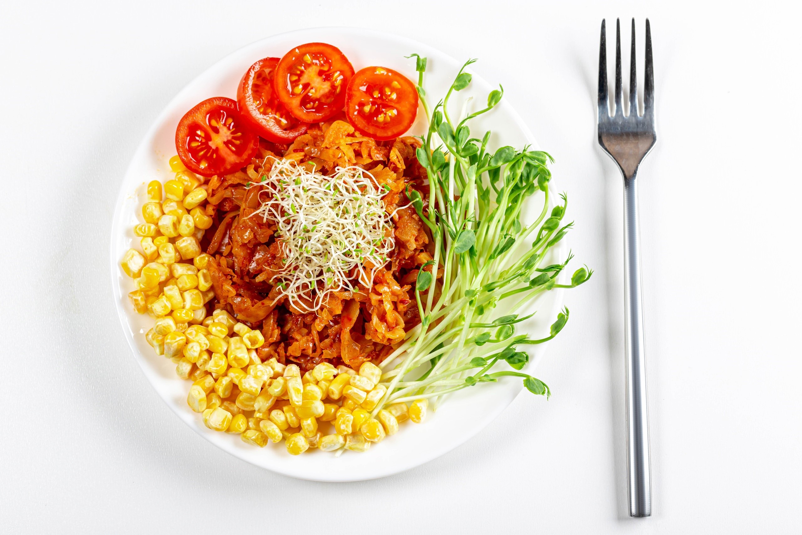 Plate of food with corn, tomatoes, sprouts, and fork HD Wallpaper