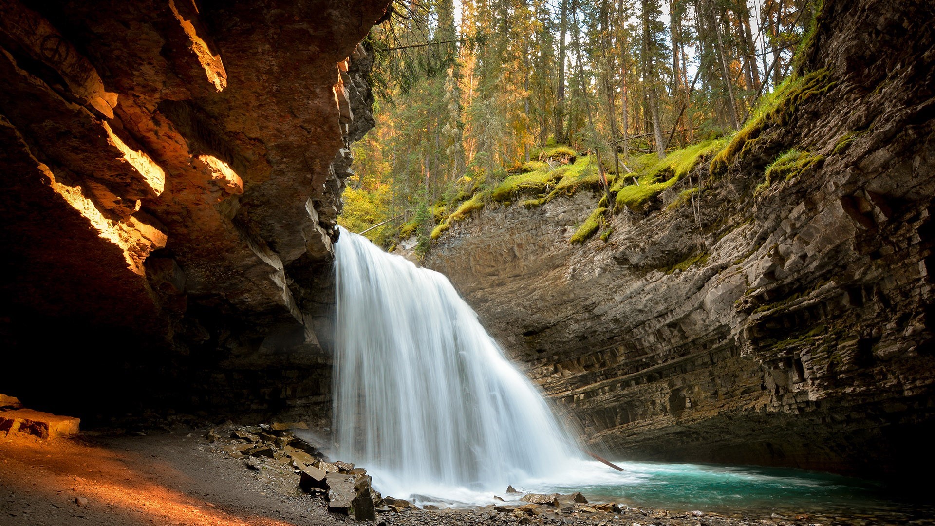 Waterfall in a rocky canyon with a forest backdrop HD Wallpaper