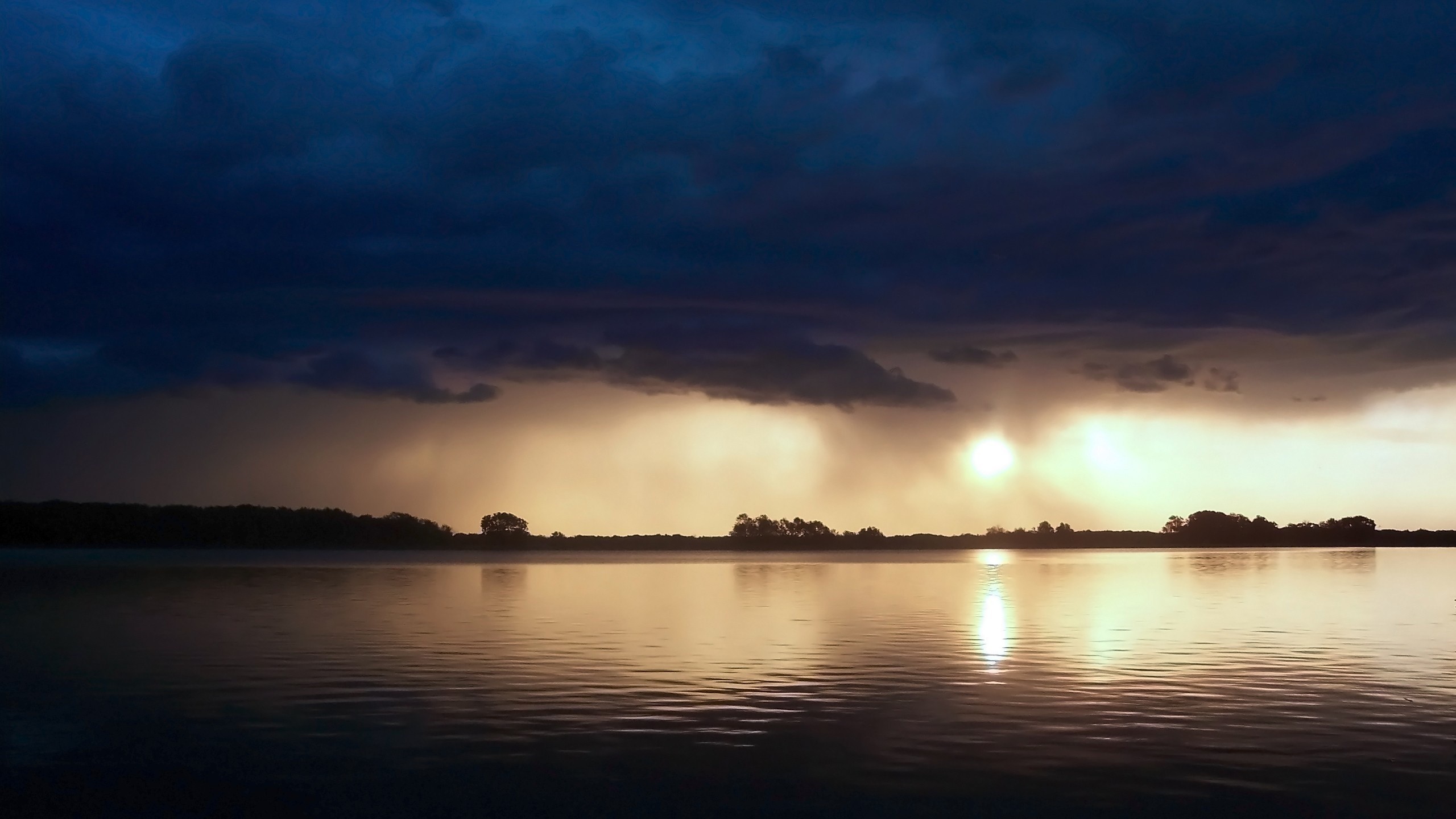 Sunset over a calm lake with dramatic clouds HD Wallpaper