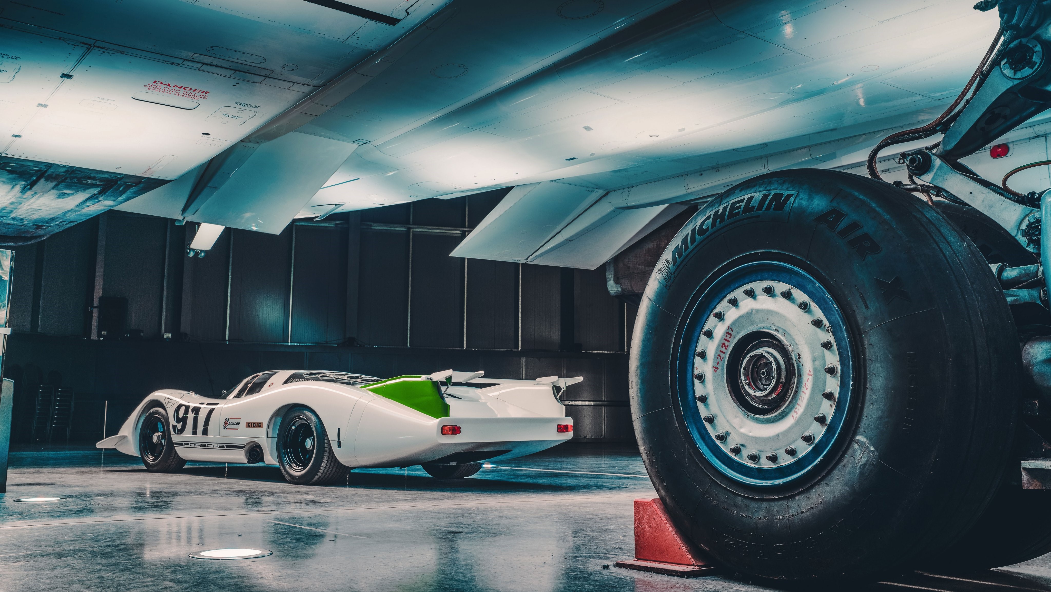 Porsche 917-001 under Concorde 002 in hangar HD Wallpaper