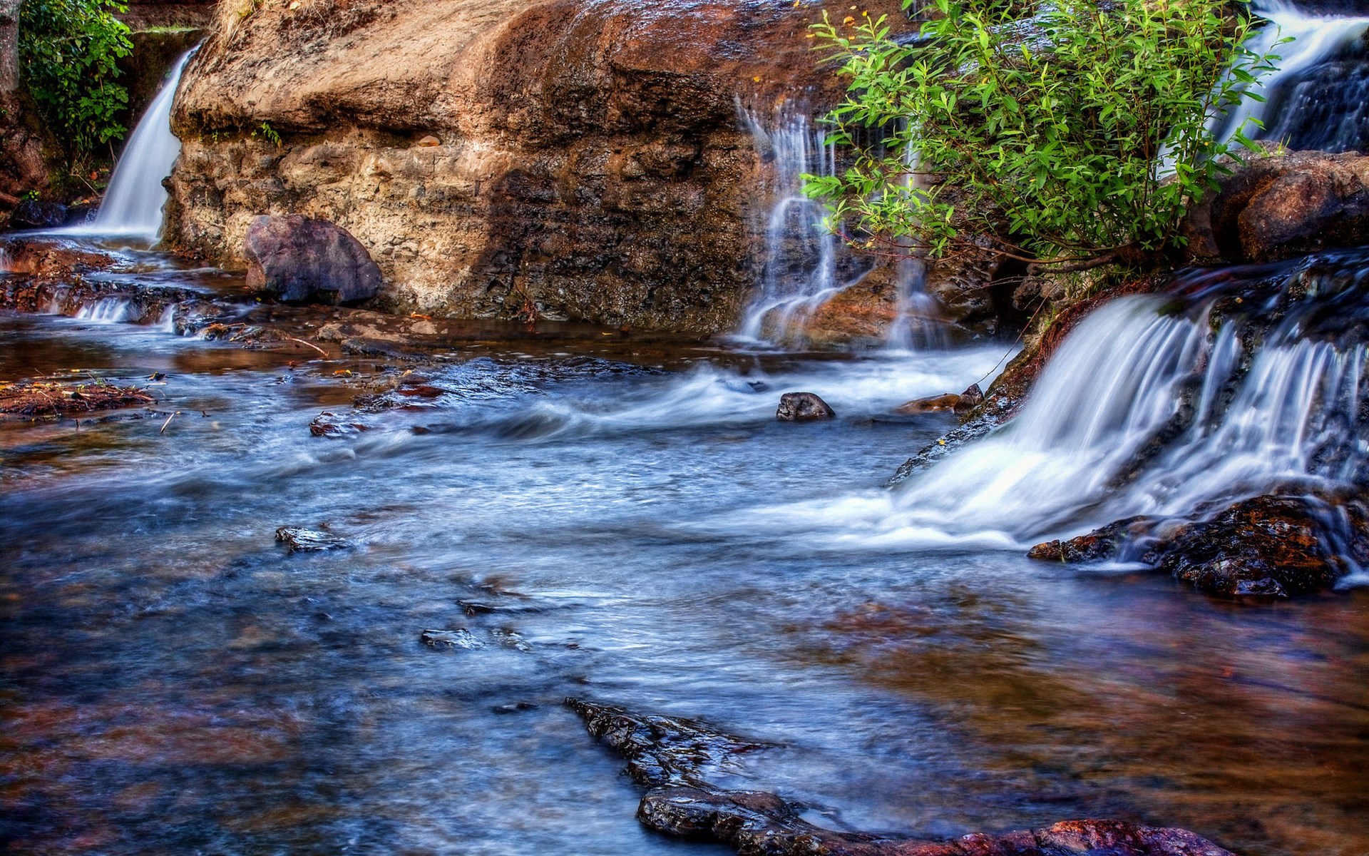 Waterfalls flowing over rocks in a stream HD Wallpaper