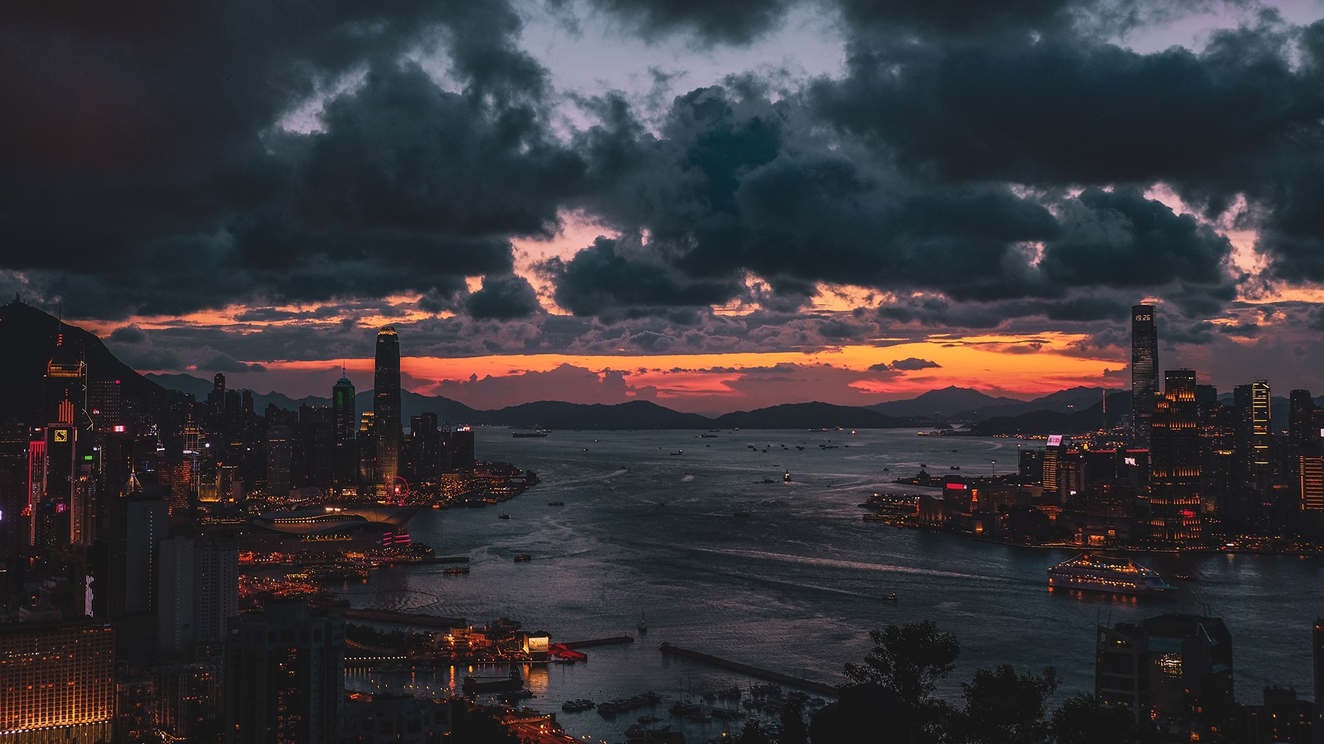 Hong Kong skyline at sunset with dramatic clouds HD Wallpaper