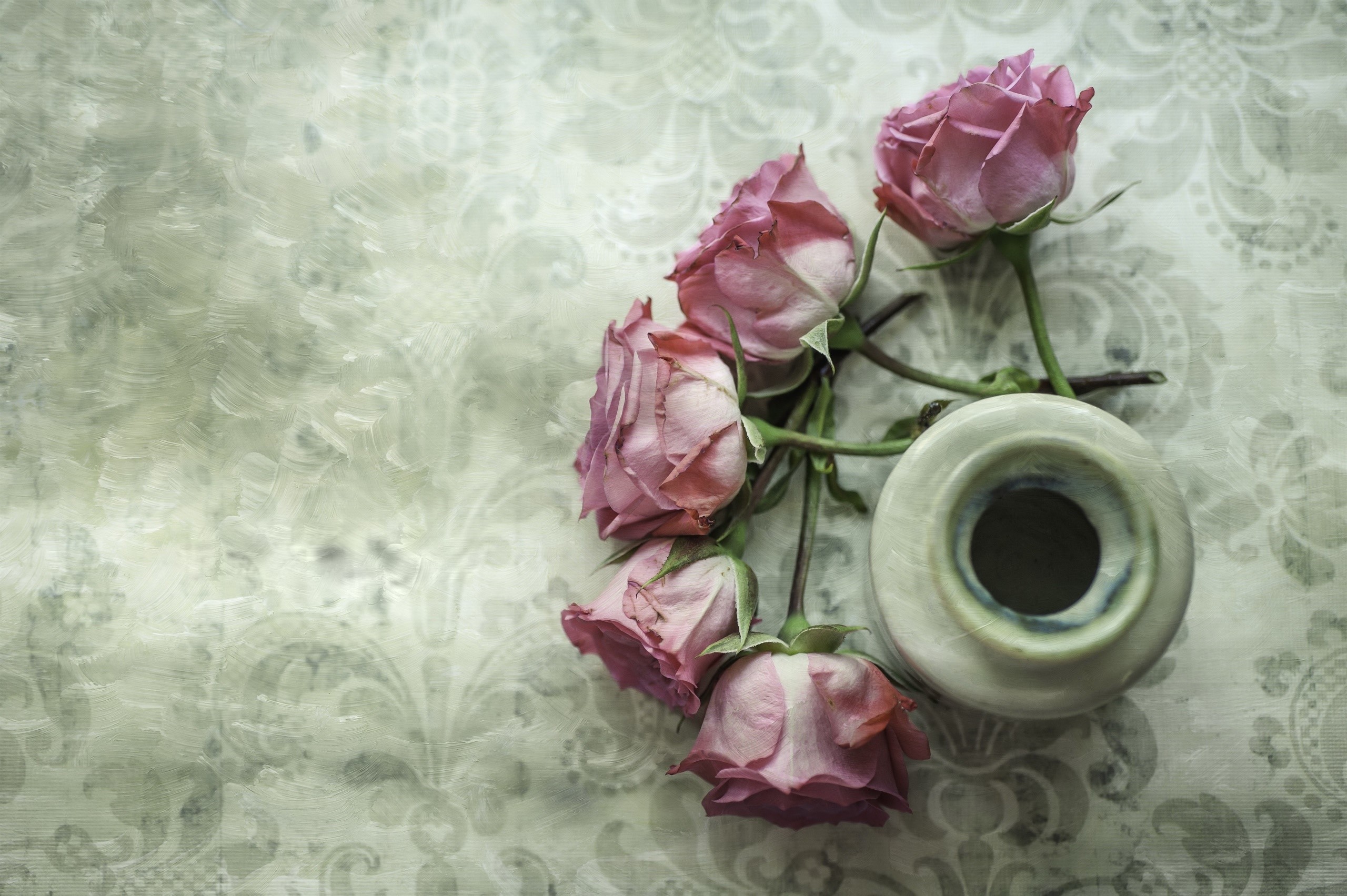 Pink roses in a small vase on a patterned surface HD Wallpaper