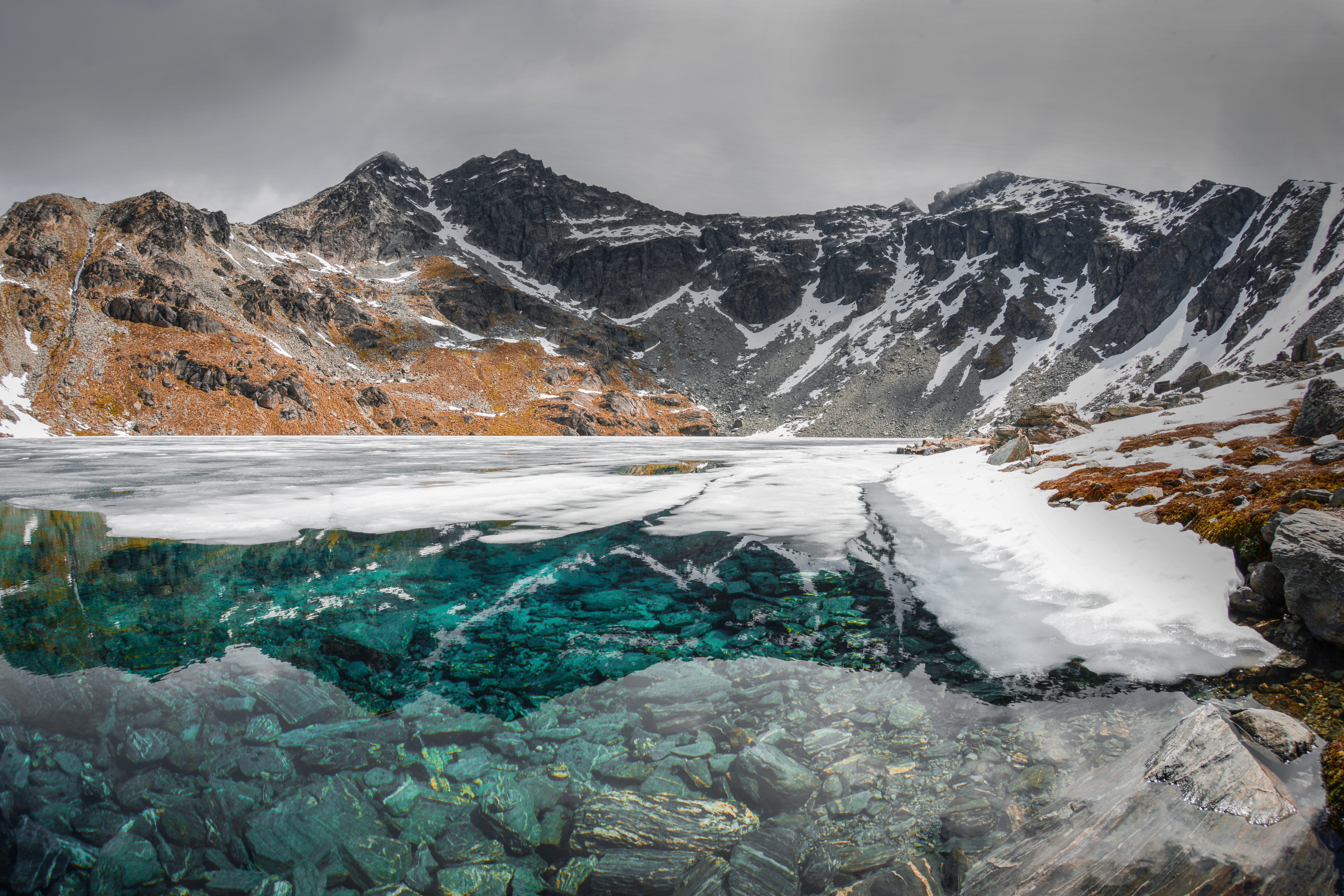 4K landscape of a partially frozen lake with mountains HD Wallpaper