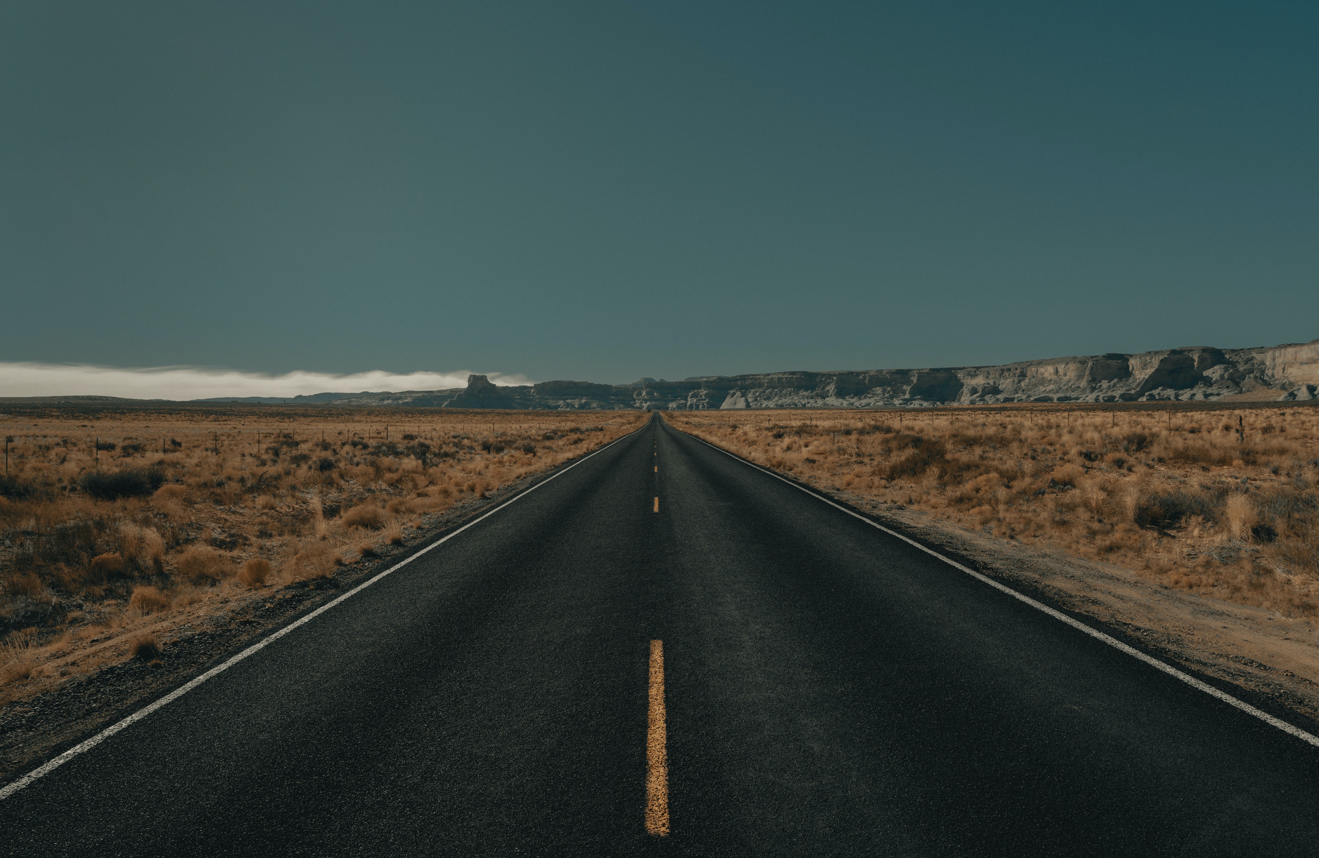 4K road through a desert landscape with mountains HD Wallpaper