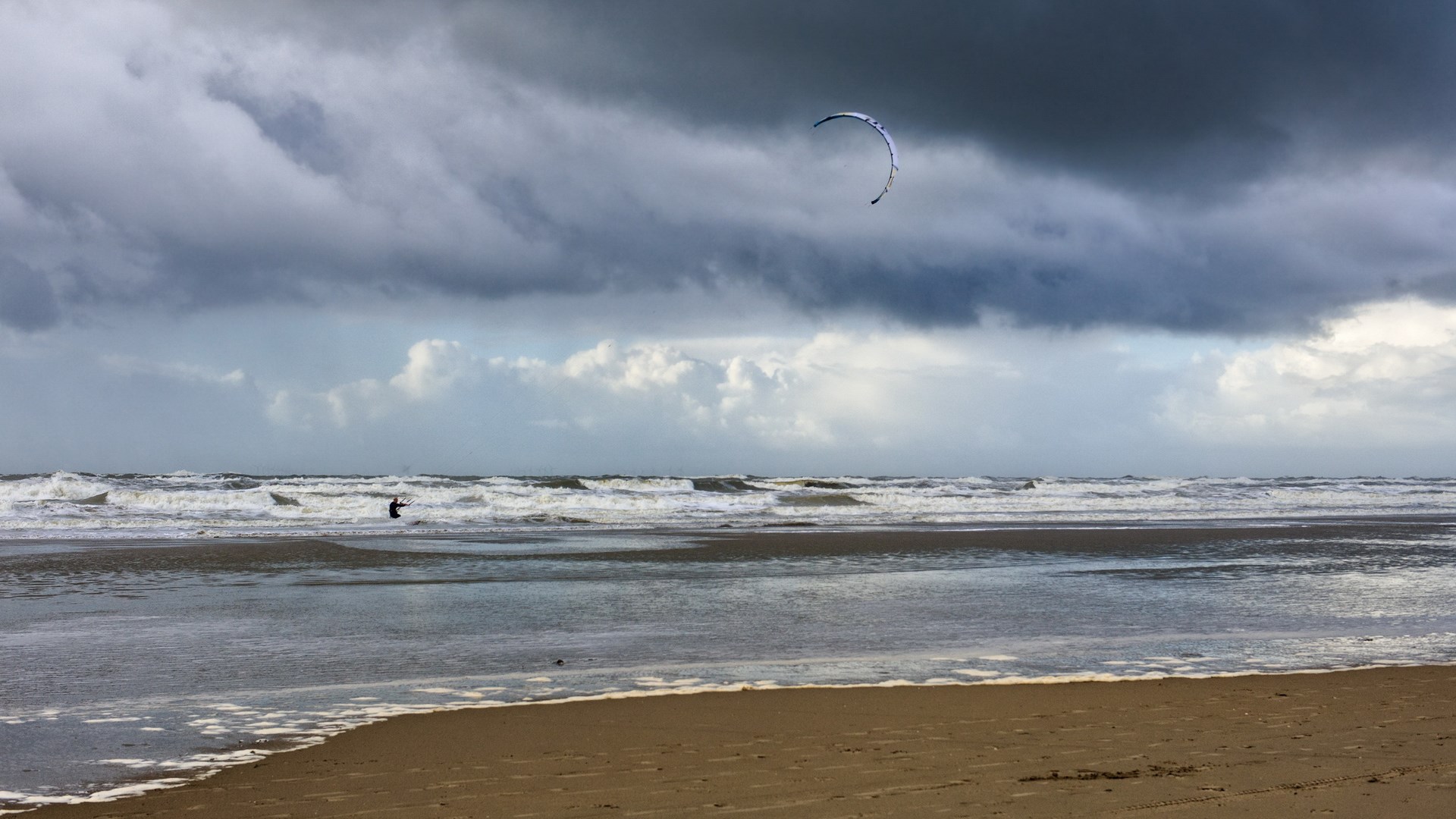 Kitesurfer on a stormy beach with waves HD Wallpaper