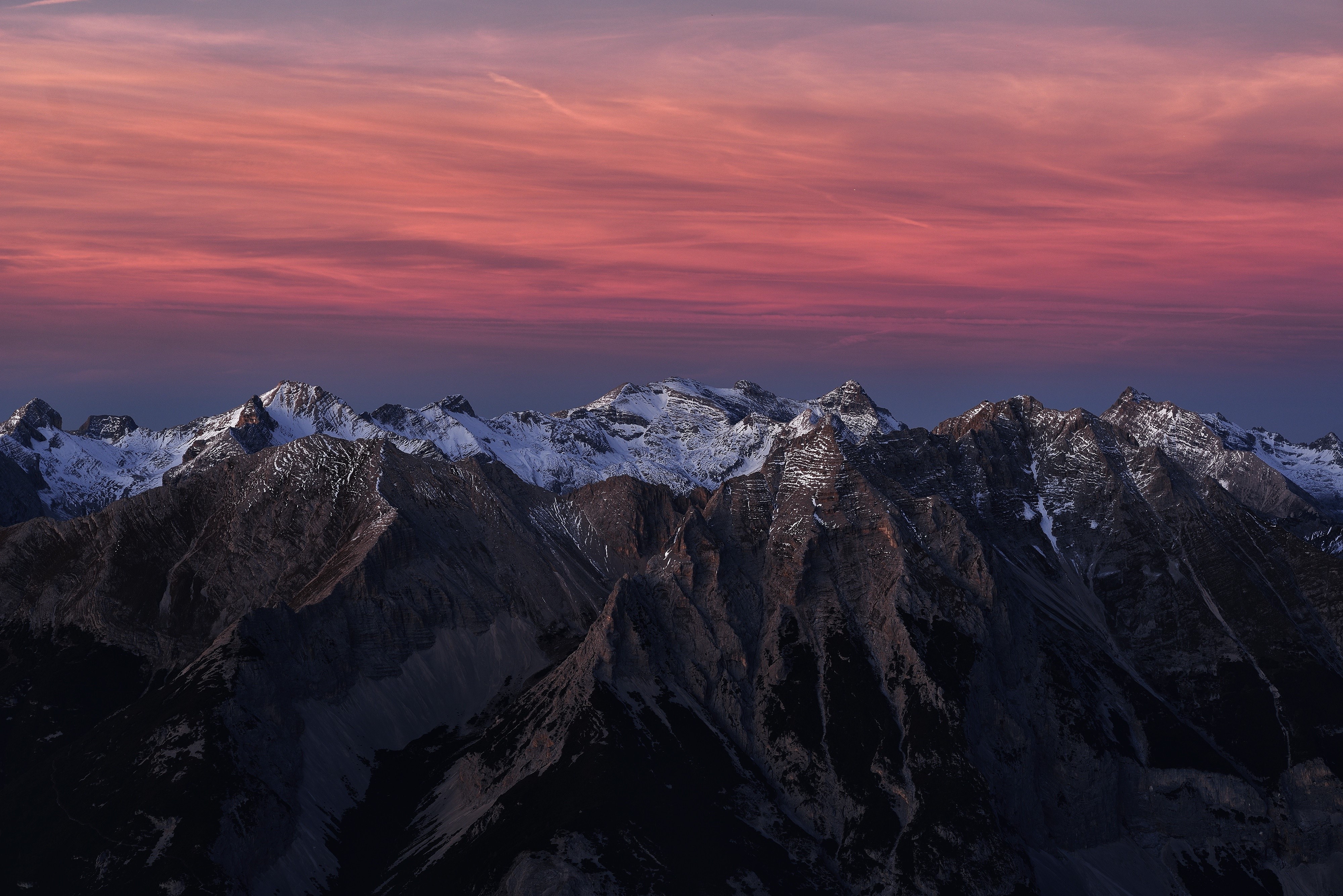 Snowy mountain range at sunset with red sky HD Wallpaper