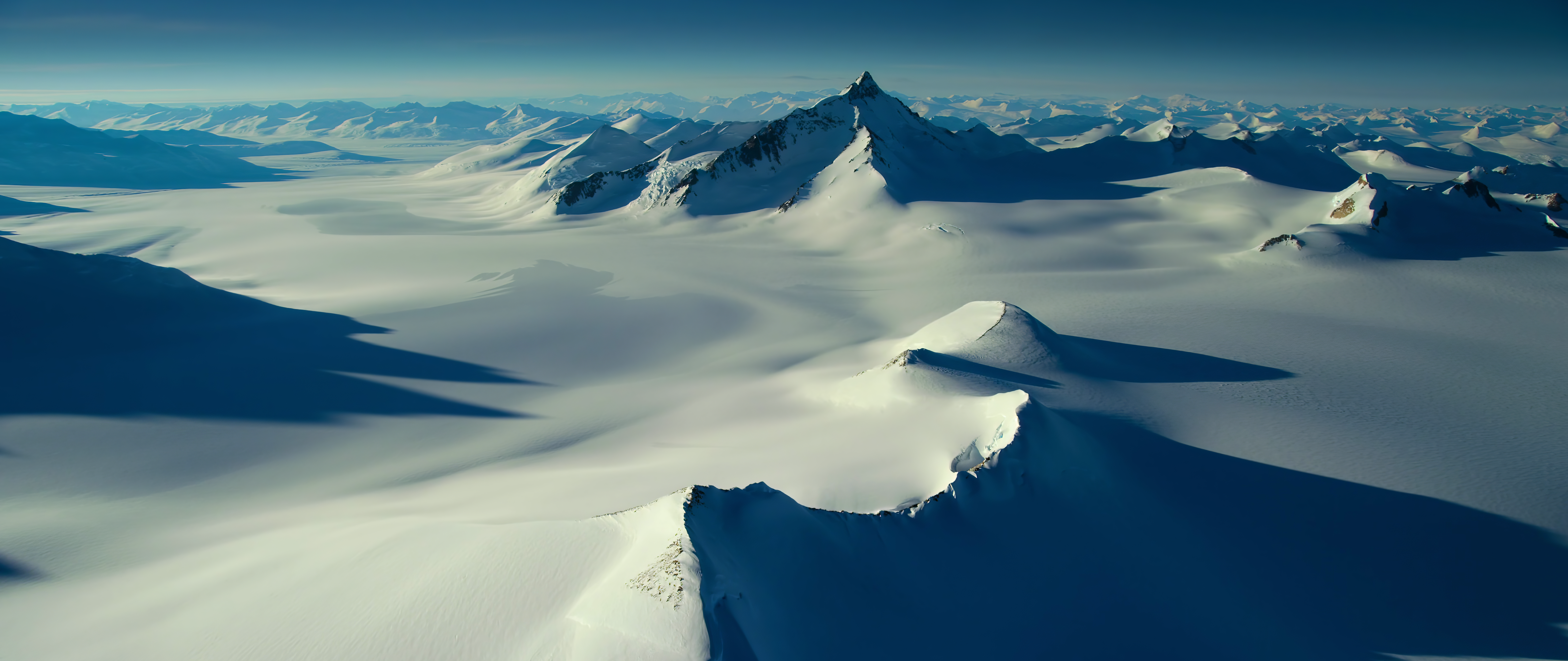 Snowy mountain peaks and glaciers under a clear blue sky HD Wallpaper